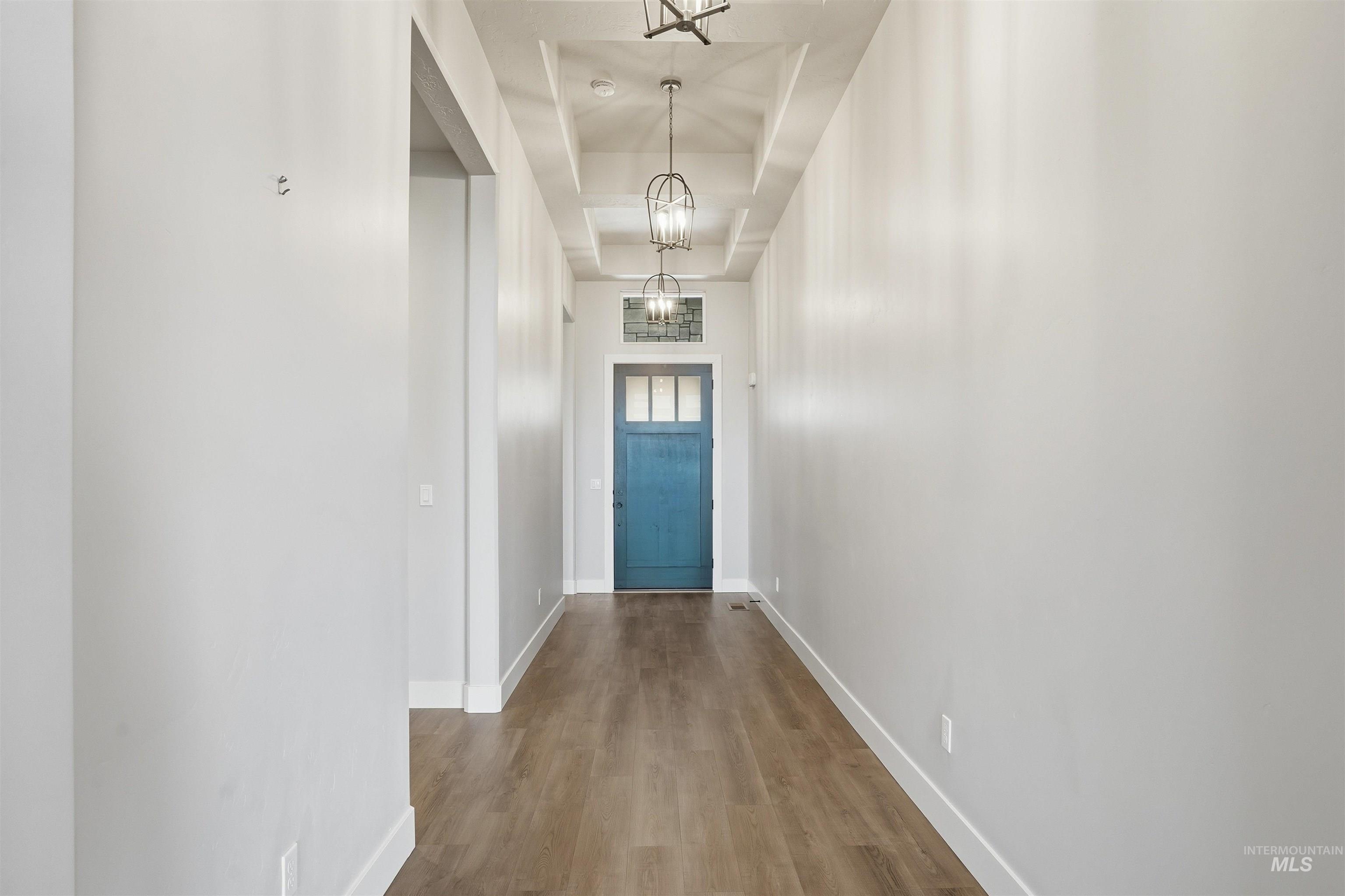 Doorway to outside featuring wood finished floors and a raised ceiling