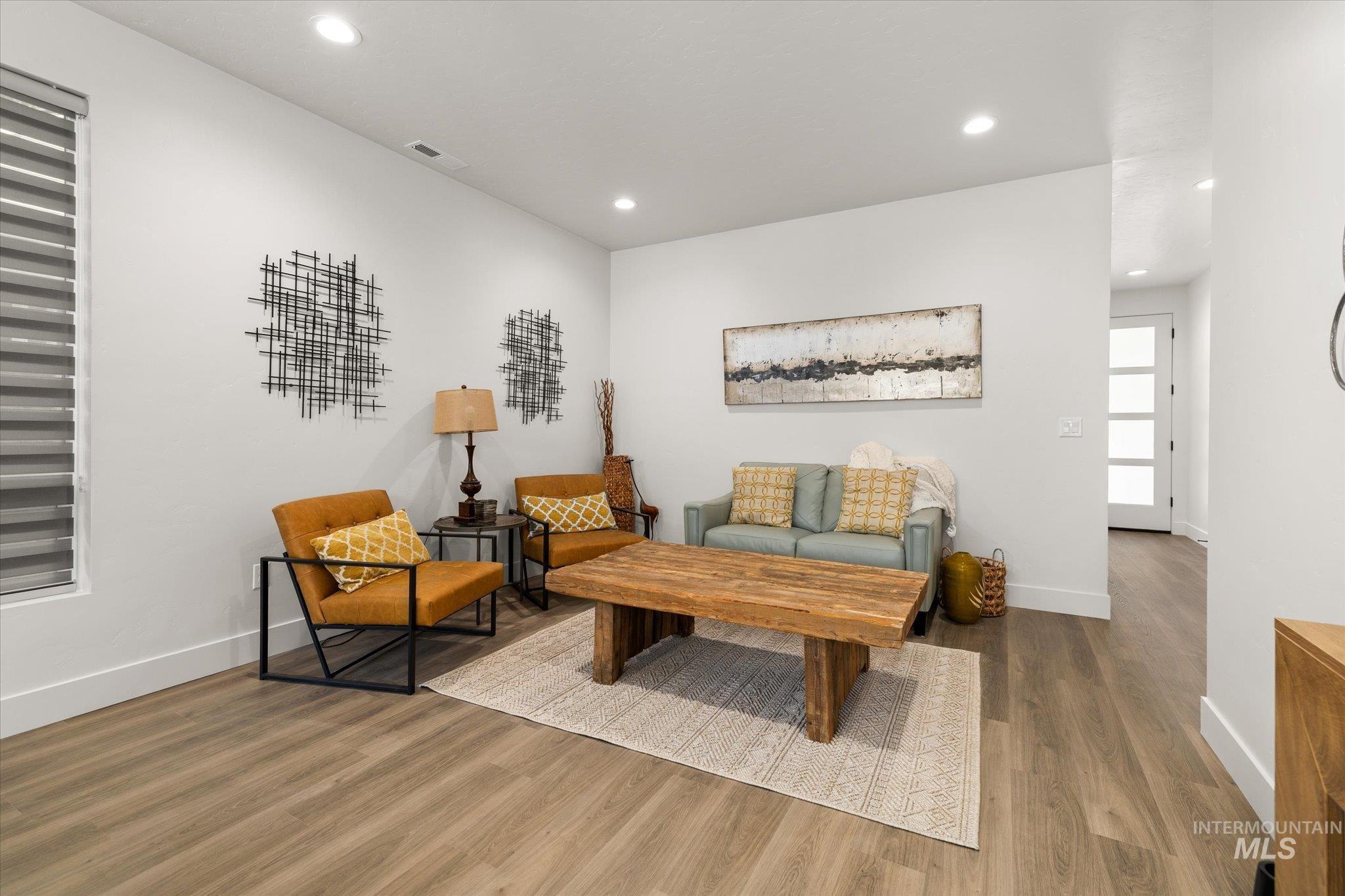 Sitting room with wood finished floors and recessed lighting