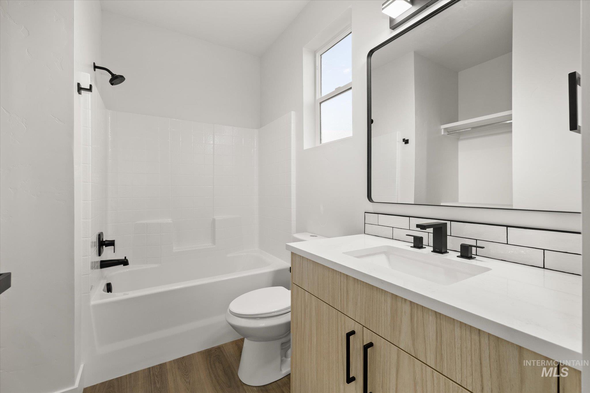 Full bathroom featuring dark wood finished floors, shower / bathtub combination, and vanity
