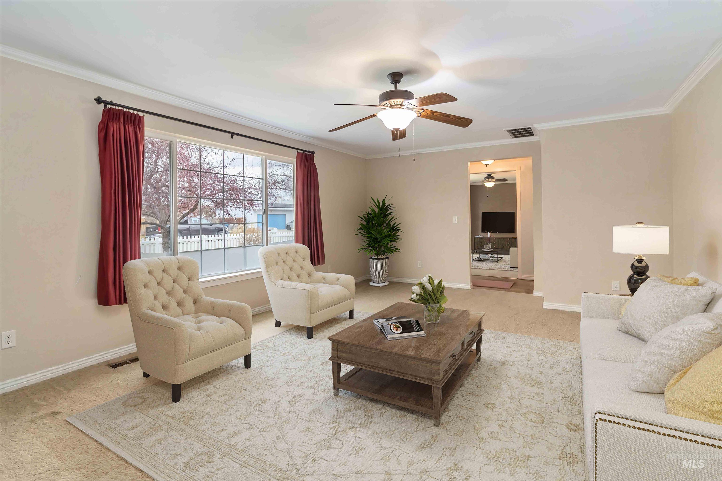 Living area with light colored carpet, crown molding, and a ceiling fan