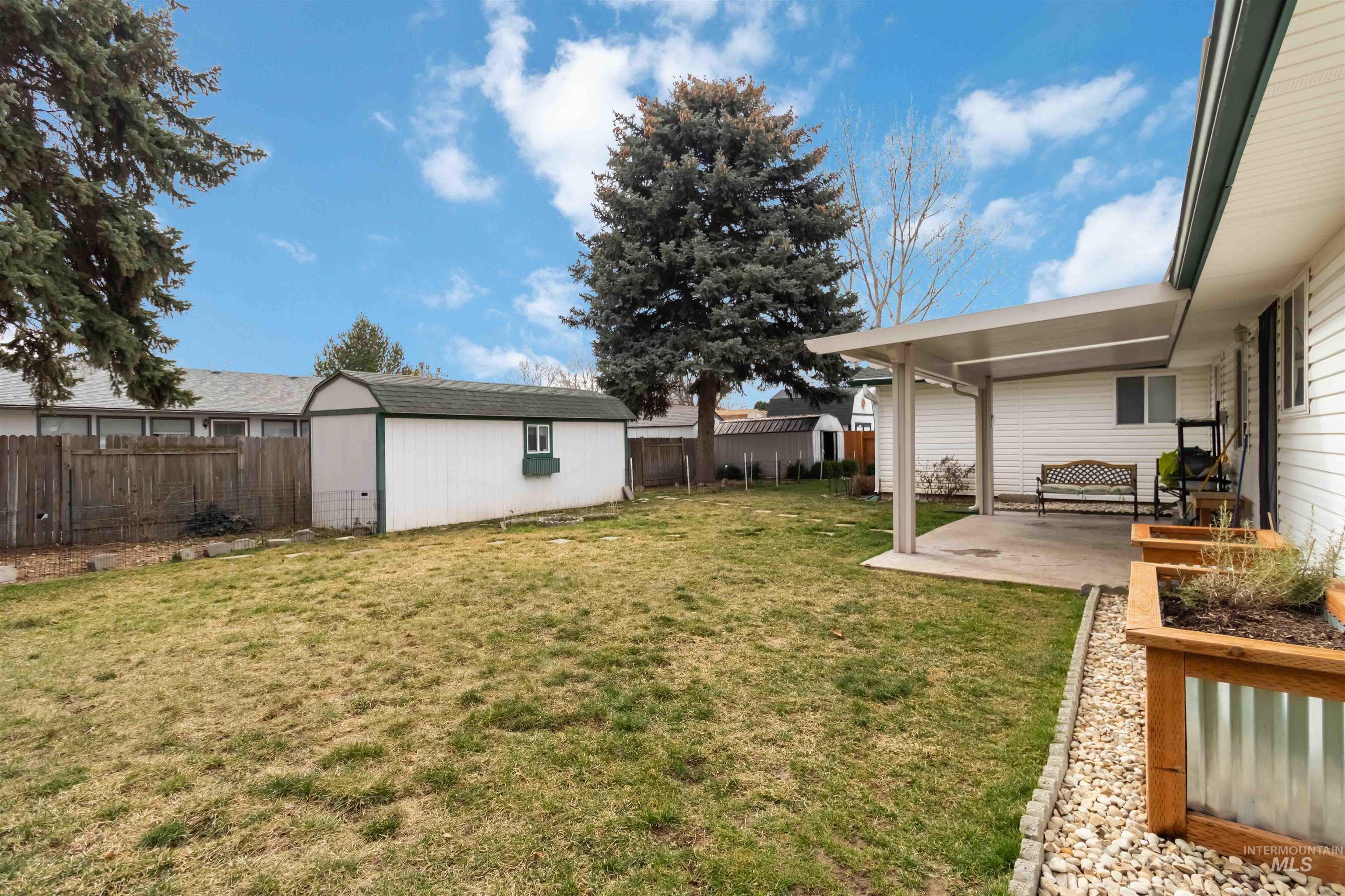Fenced backyard with a patio area and a shed