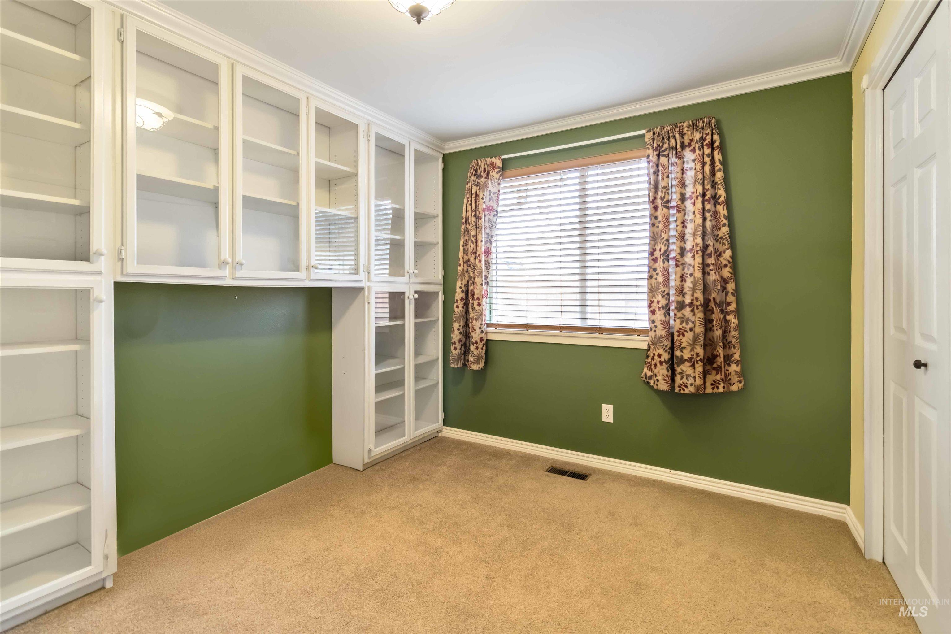 Unfurnished bedroom with light colored carpet, ornamental molding, and a closet