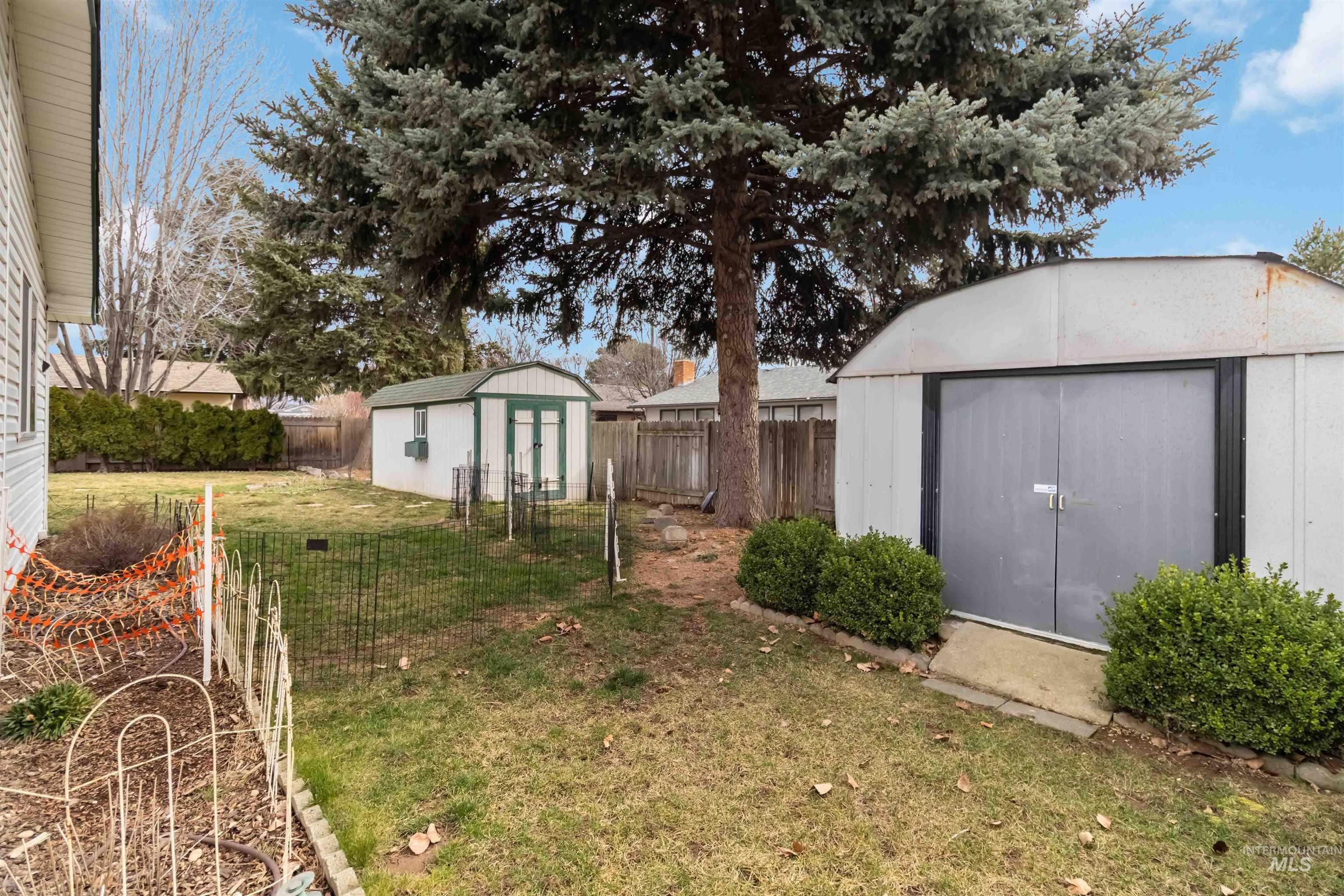 Fenced backyard featuring a shed