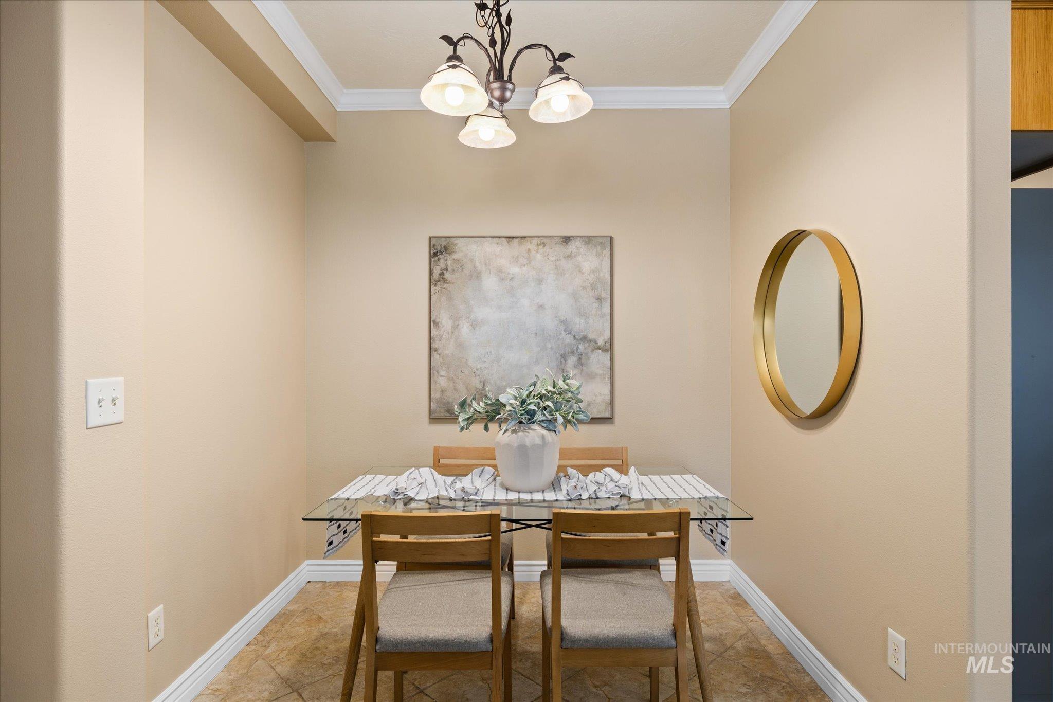Dining space with crown molding and a chandelier