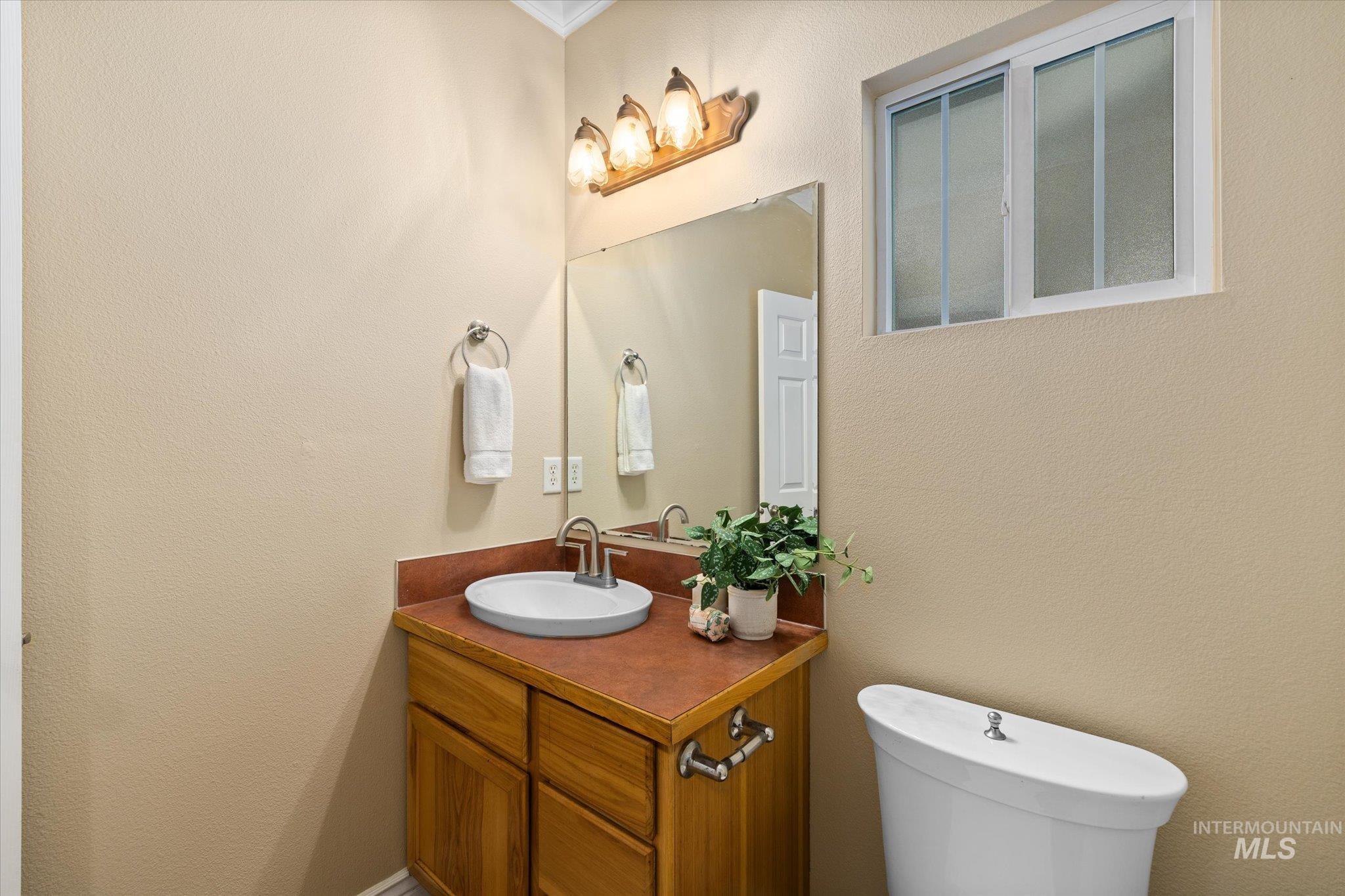 Half bathroom with a textured wall and vanity