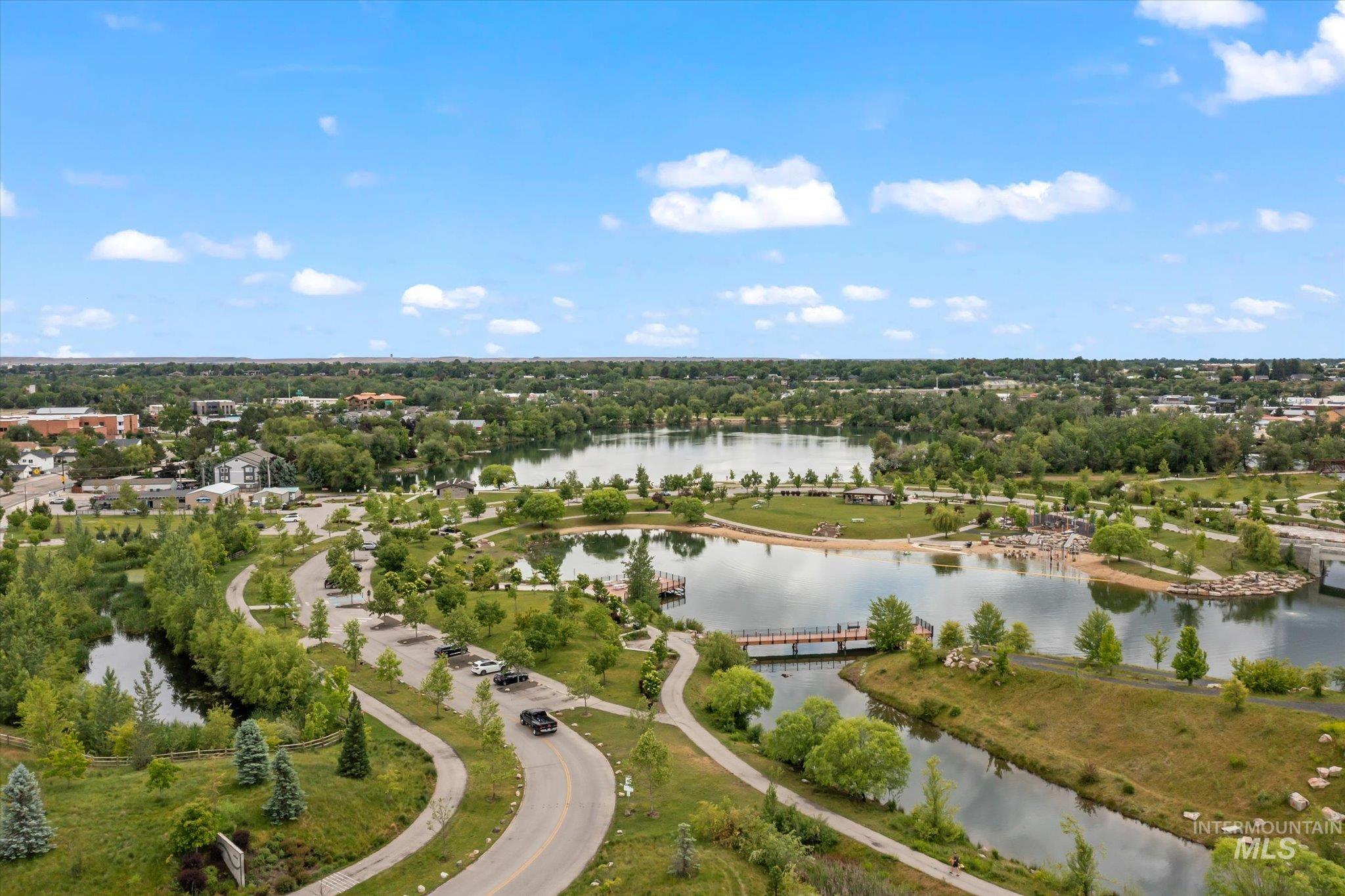 Drone / aerial view of a nearby body of water and a tree filled landscape