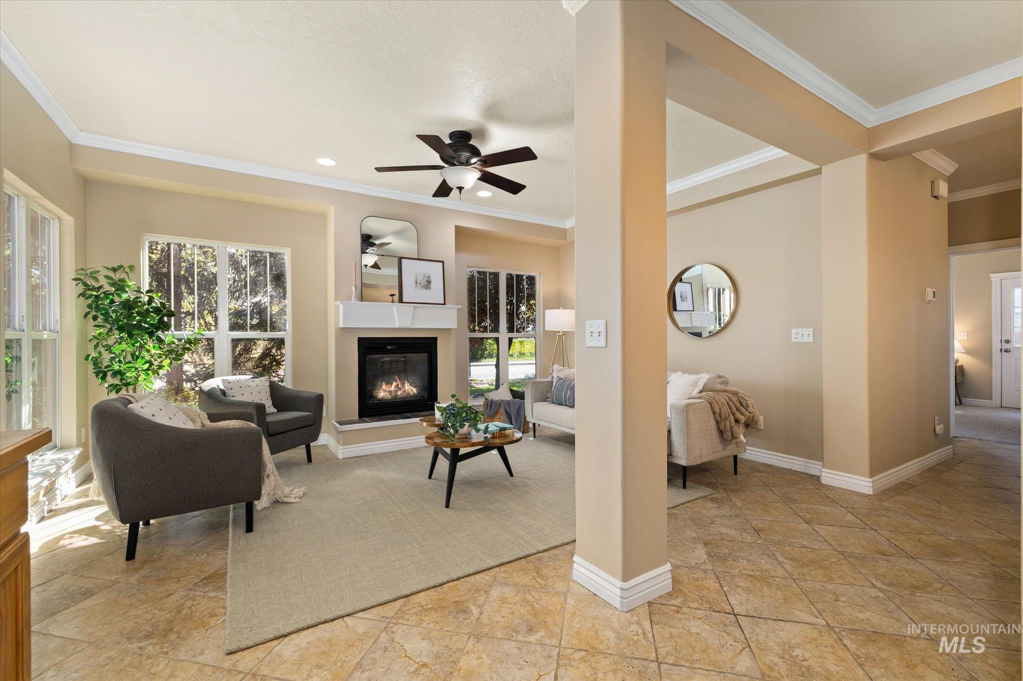 Living room featuring crown molding, a glass covered fireplace, ceiling fan, and recessed lighting