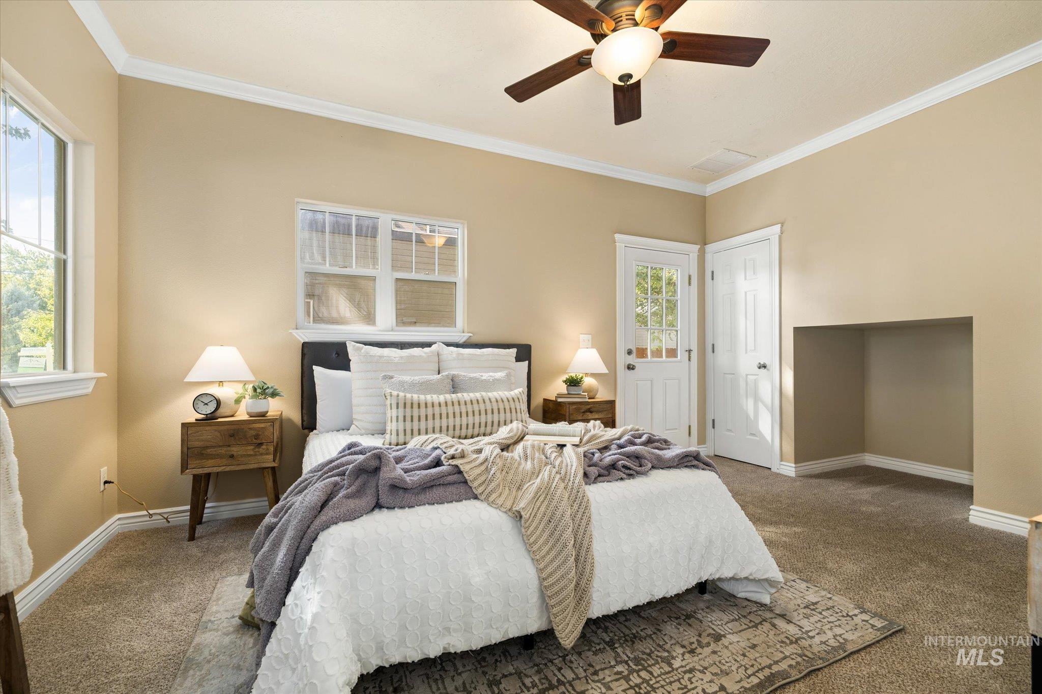 Carpeted bedroom with crown molding and ceiling fan
