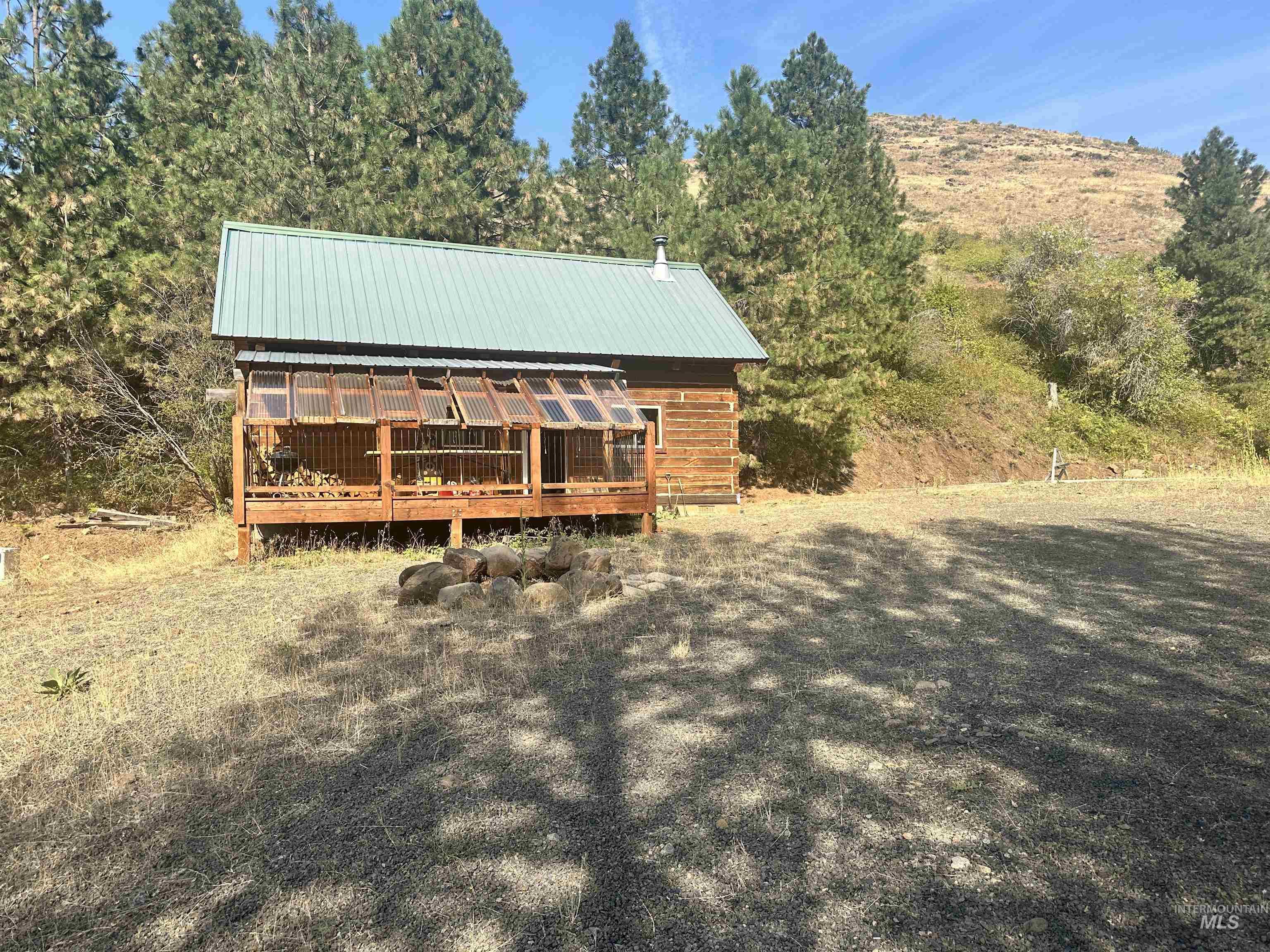 View of front of home featuring a deck and a metal roof