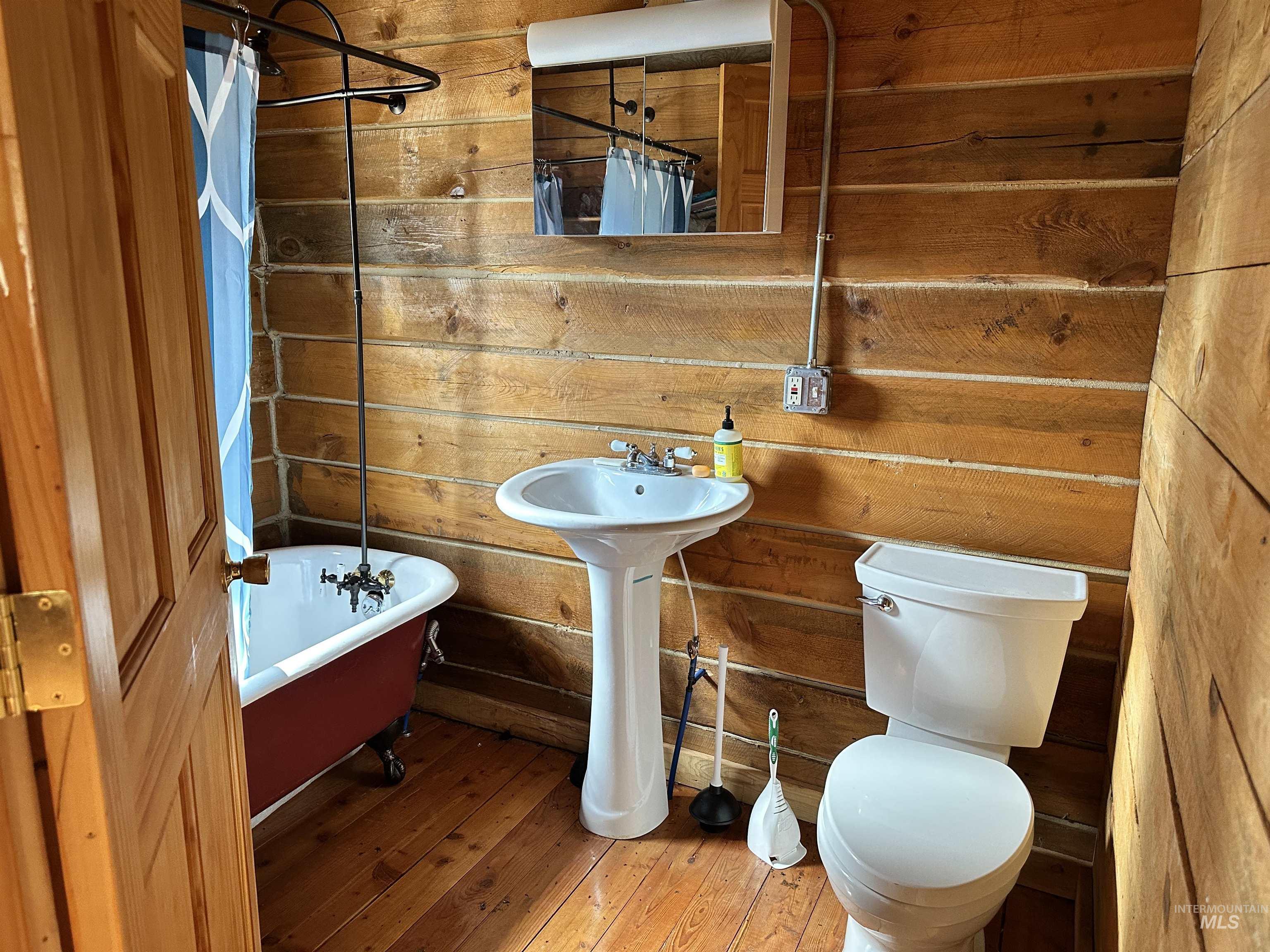 Full bath with wood walls and hardwood / wood-style flooring