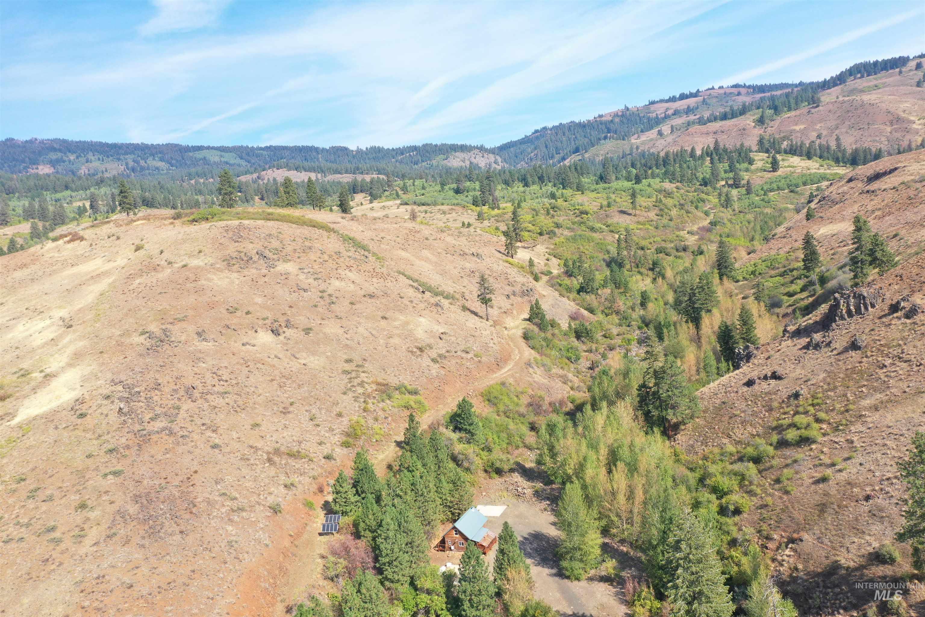 Aerial view of property's location with mountains and a forest