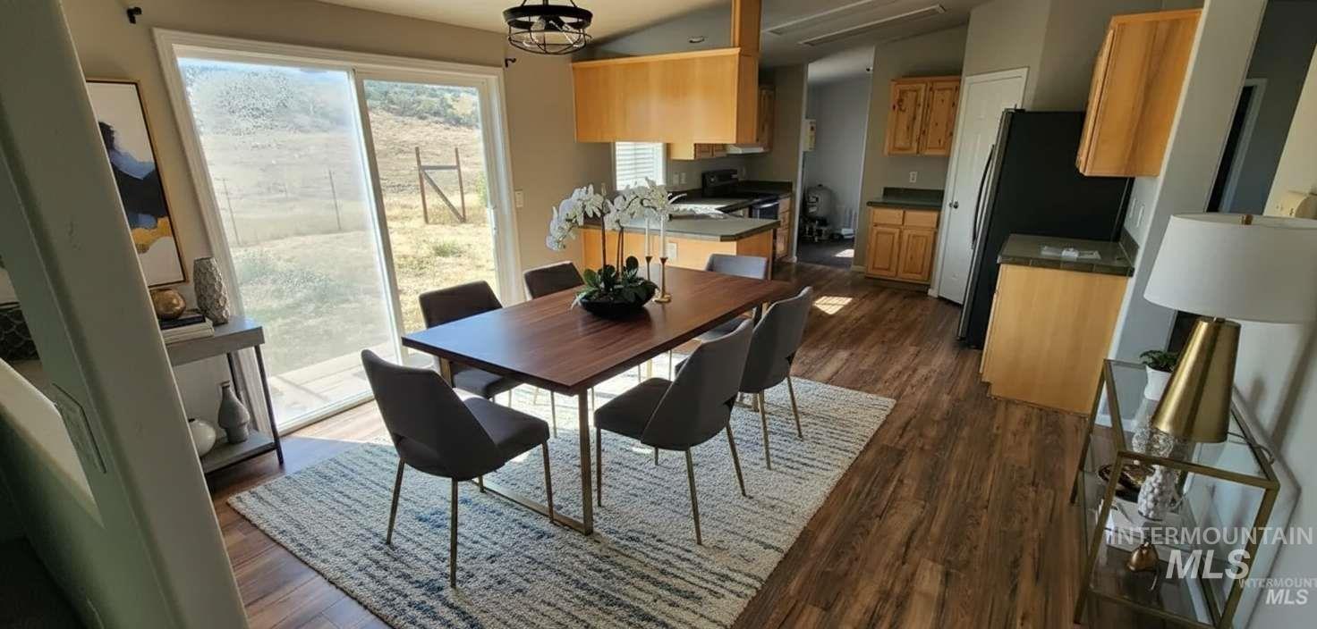 Dining room featuring dark wood-style floors, lofted ceiling, and a chandelier