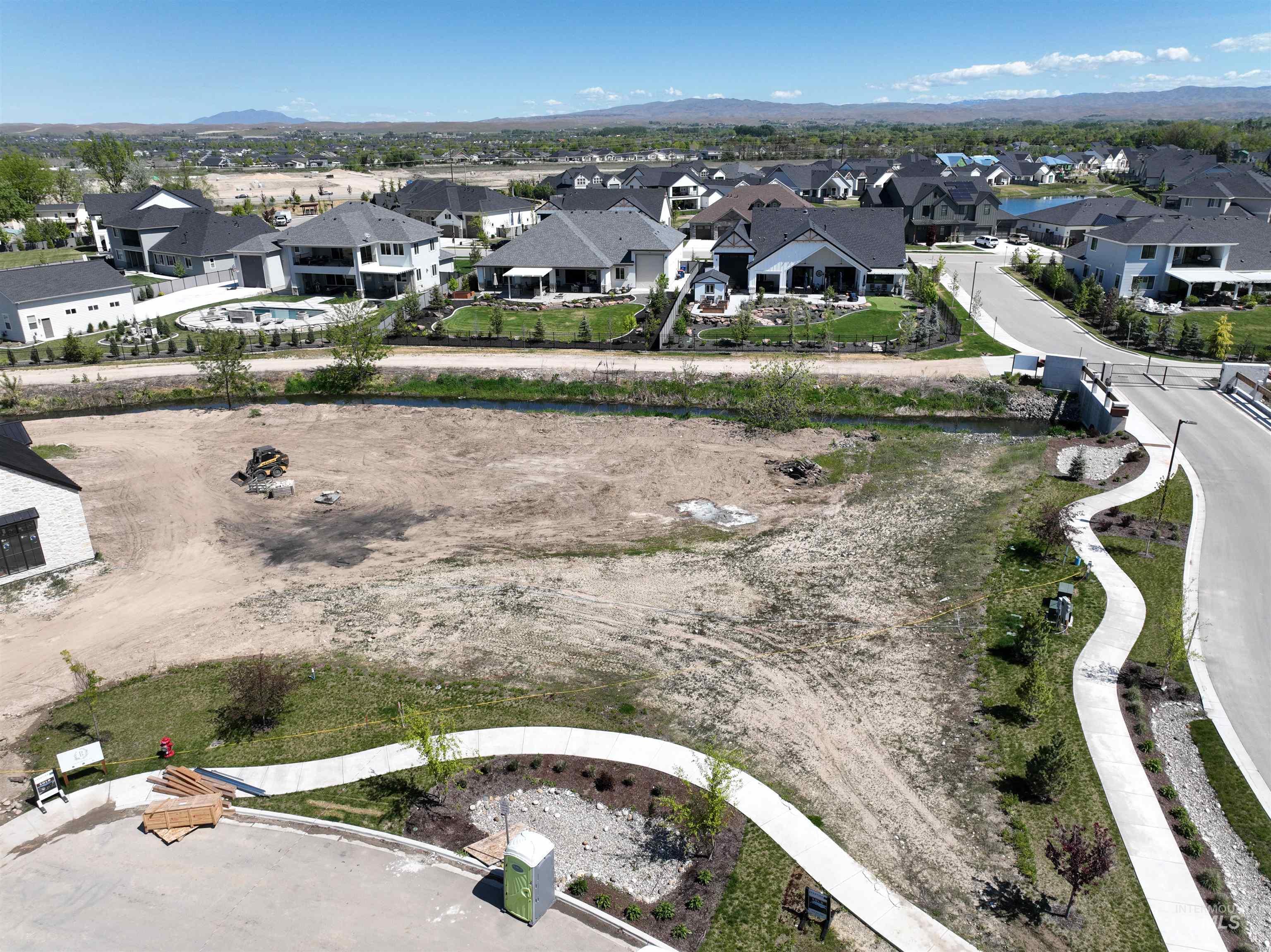 Aerial view of property and surrounding area featuring nearby suburban area and a mountainous background
