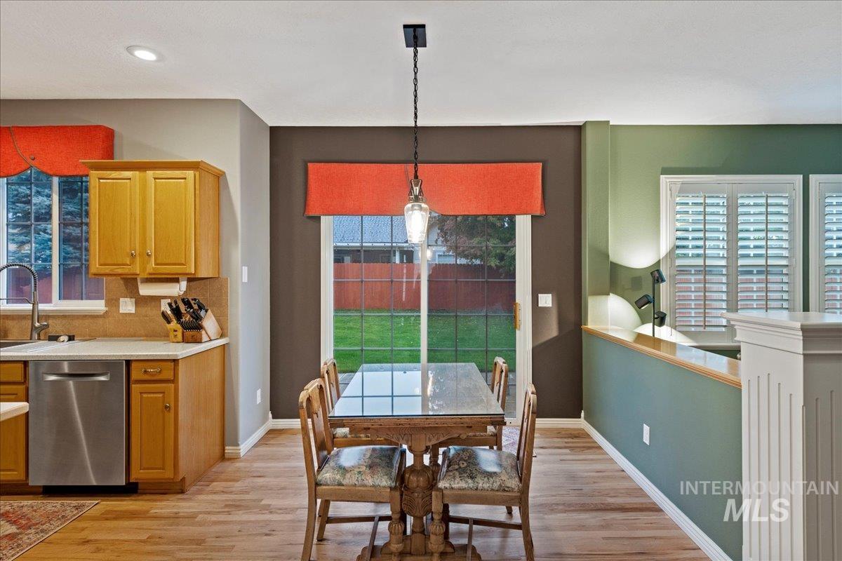 Dining room with light wood-style floors and recessed lighting
