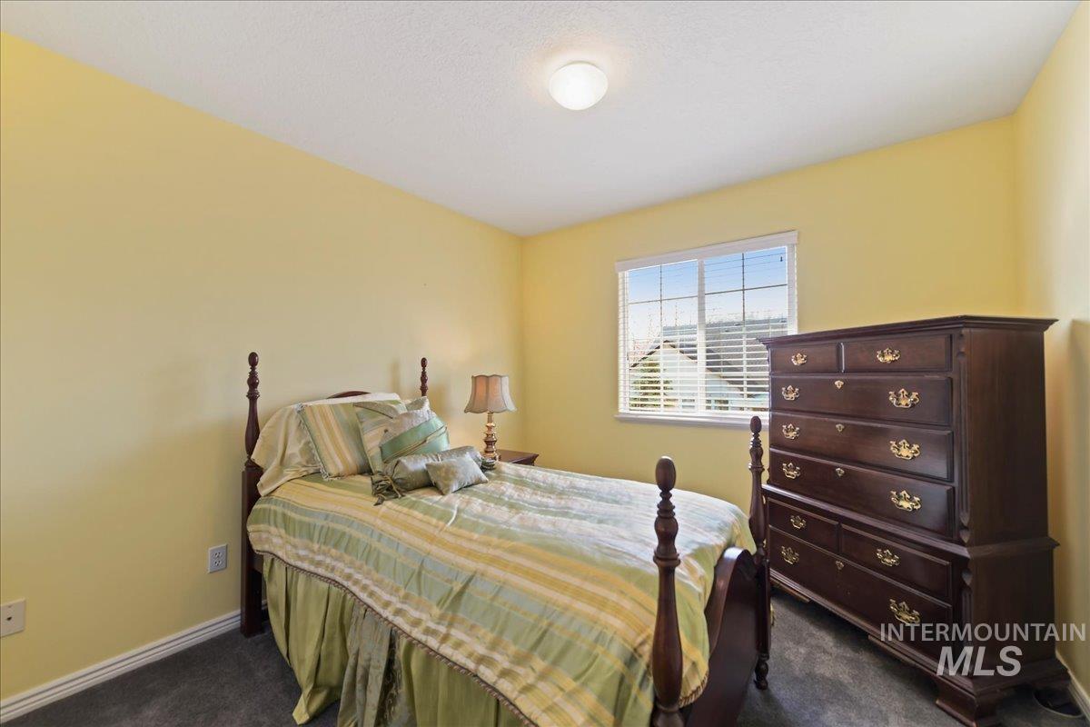 Bedroom featuring dark carpet and baseboards