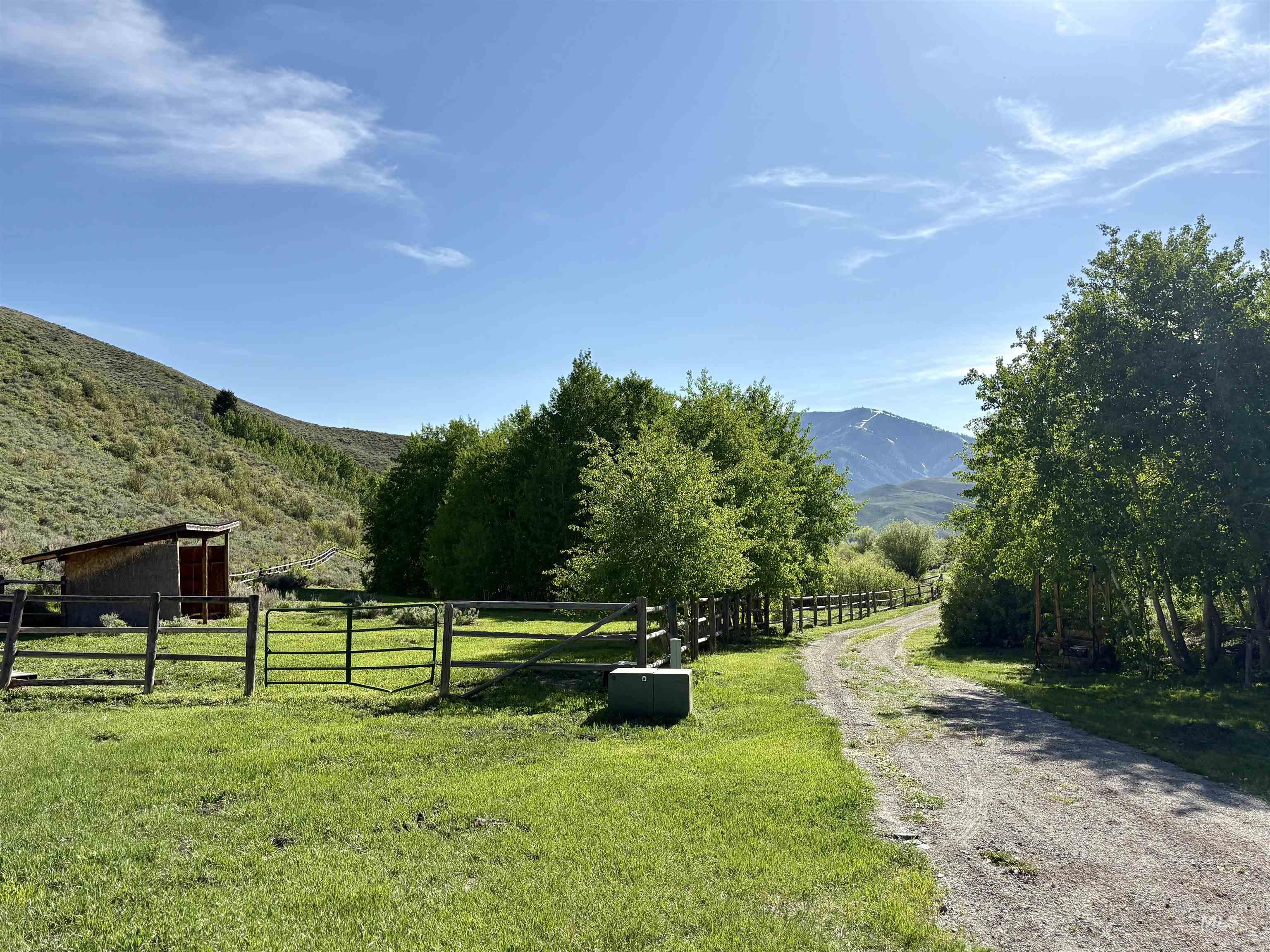 View of road with a mountain view, a gate, and a rural view