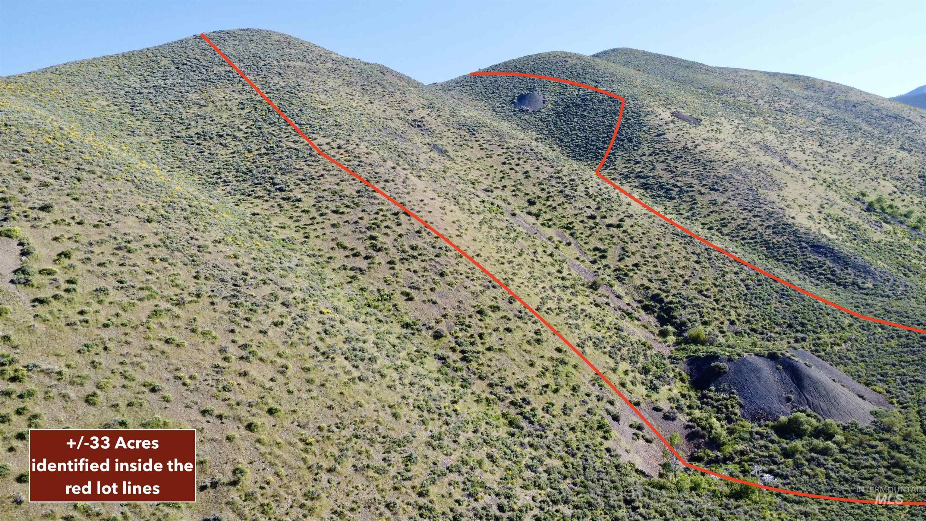 Aerial view of property and surrounding area featuring mountains and property parcel outlined