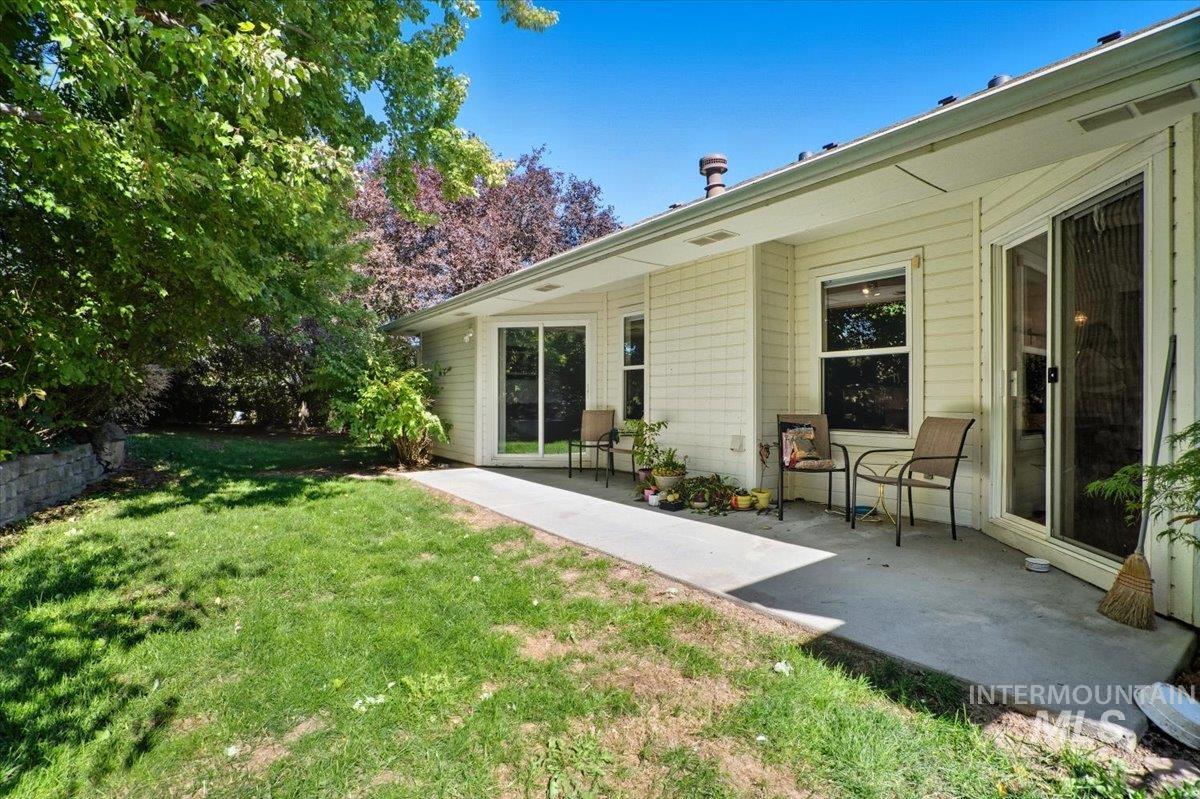 View of grassy yard featuring a patio