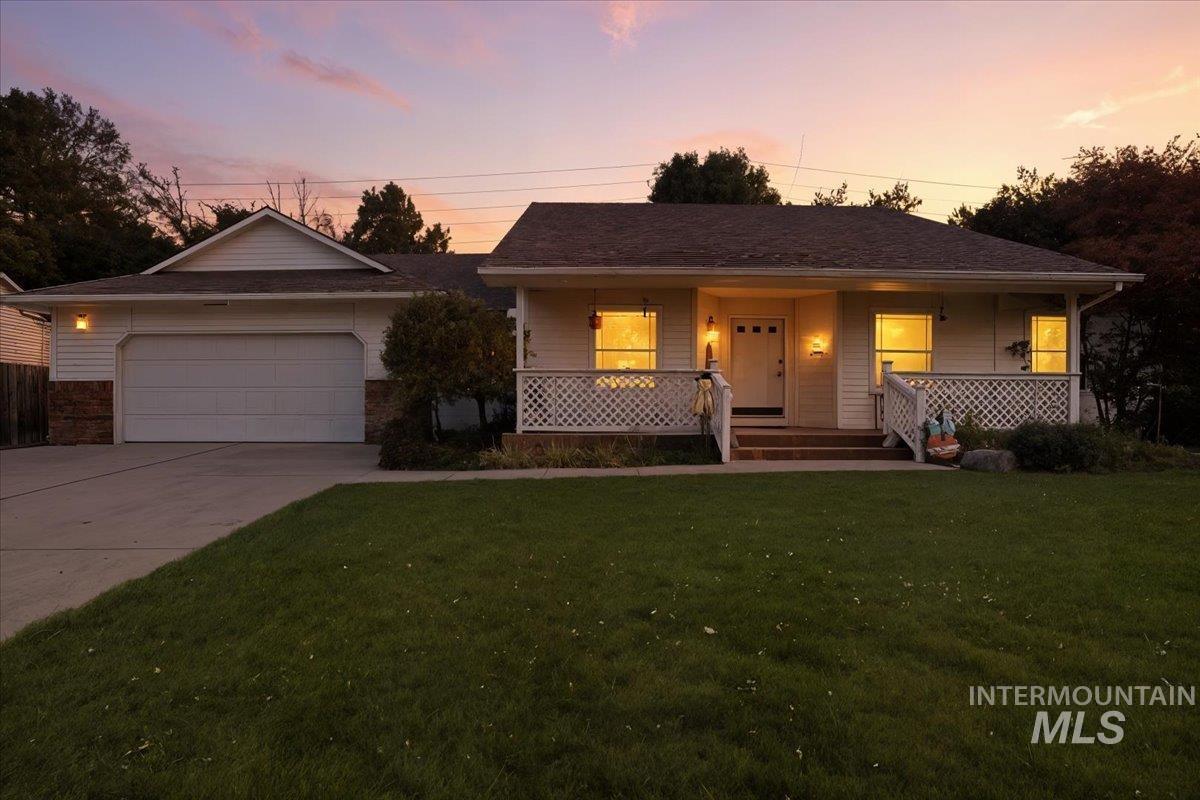 Ranch-style home featuring covered porch, mature landscaping and virtual twilight lighting.