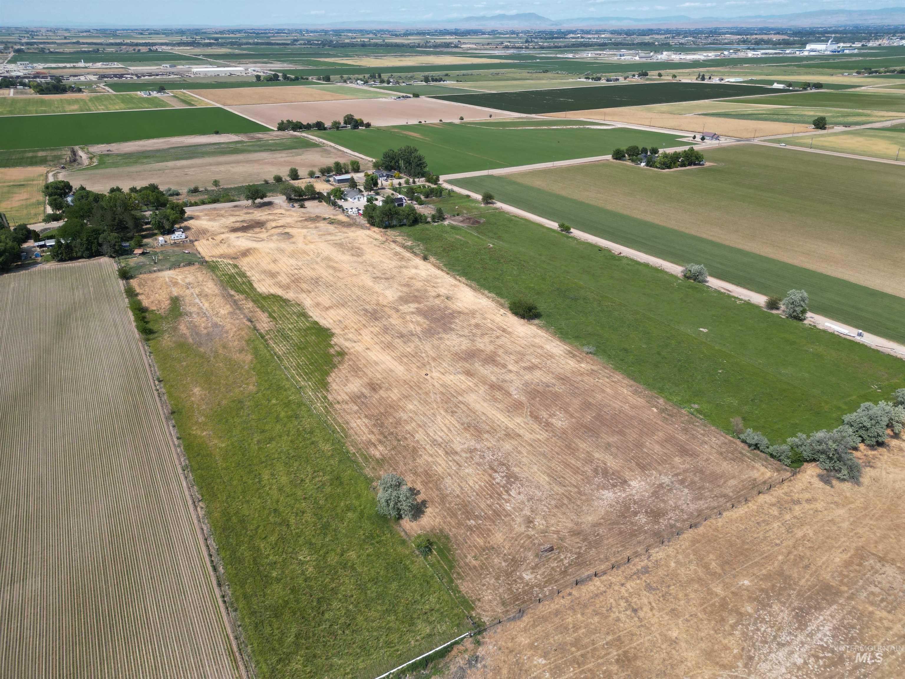 Aerial view of property and surrounding area featuring rural landscape and extensive farmland