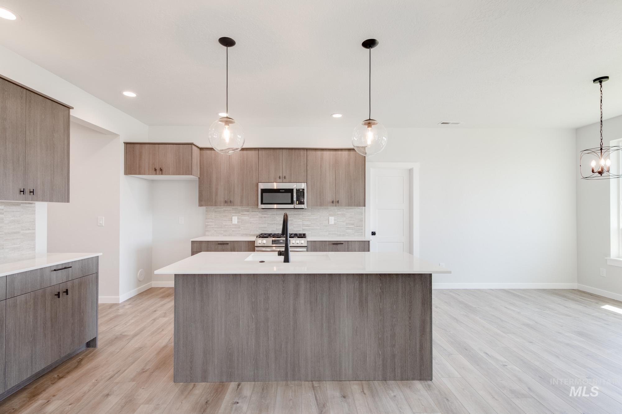 Kitchen featuring modern cabinets, light wood-style floors, light countertops, and recessed lighting