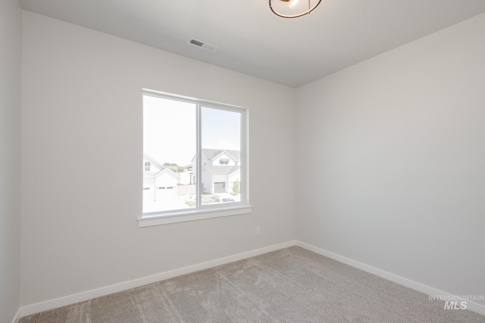 Empty room featuring light carpet and baseboards