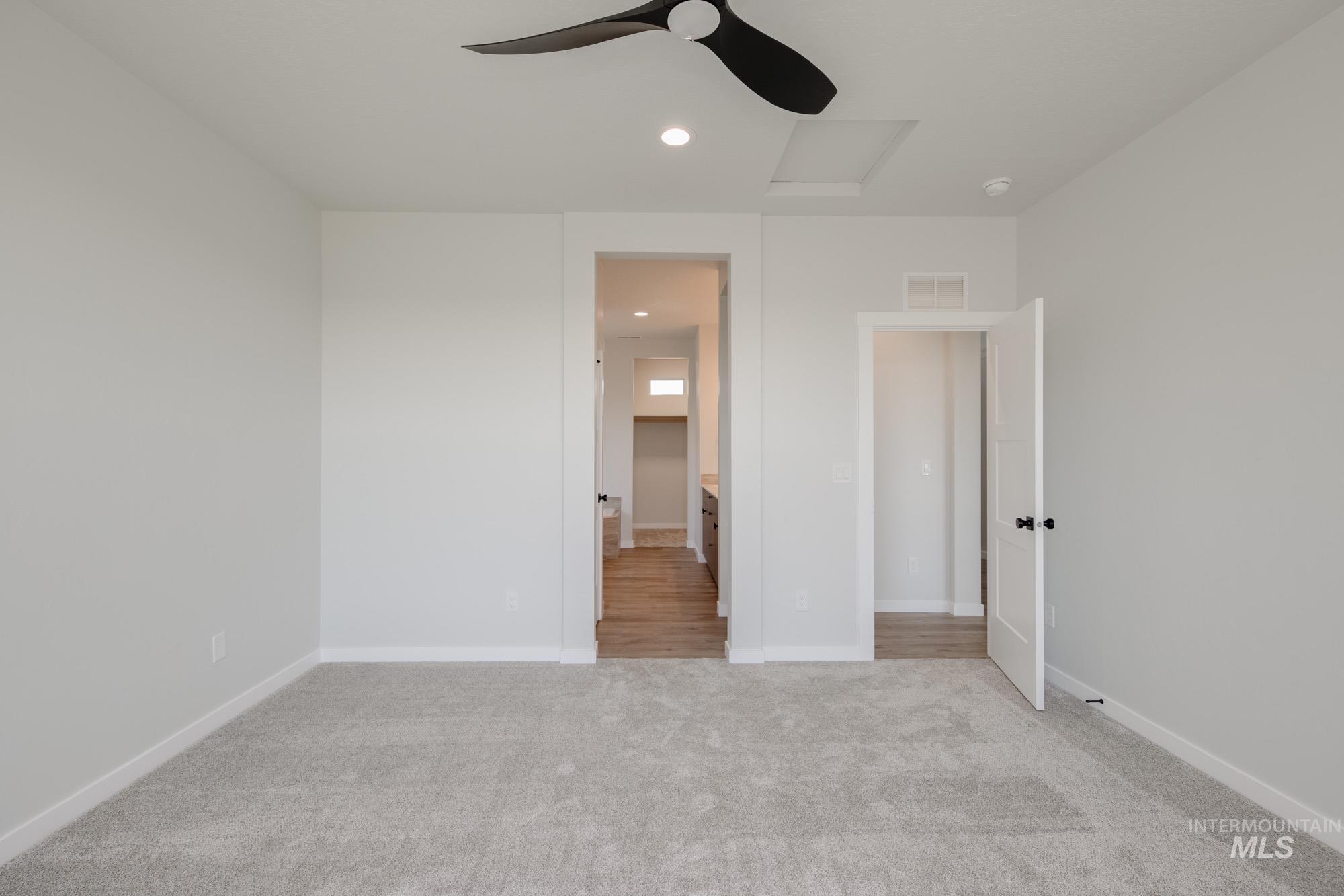 Unfurnished bedroom featuring recessed lighting, light carpet, attic access, and a ceiling fan