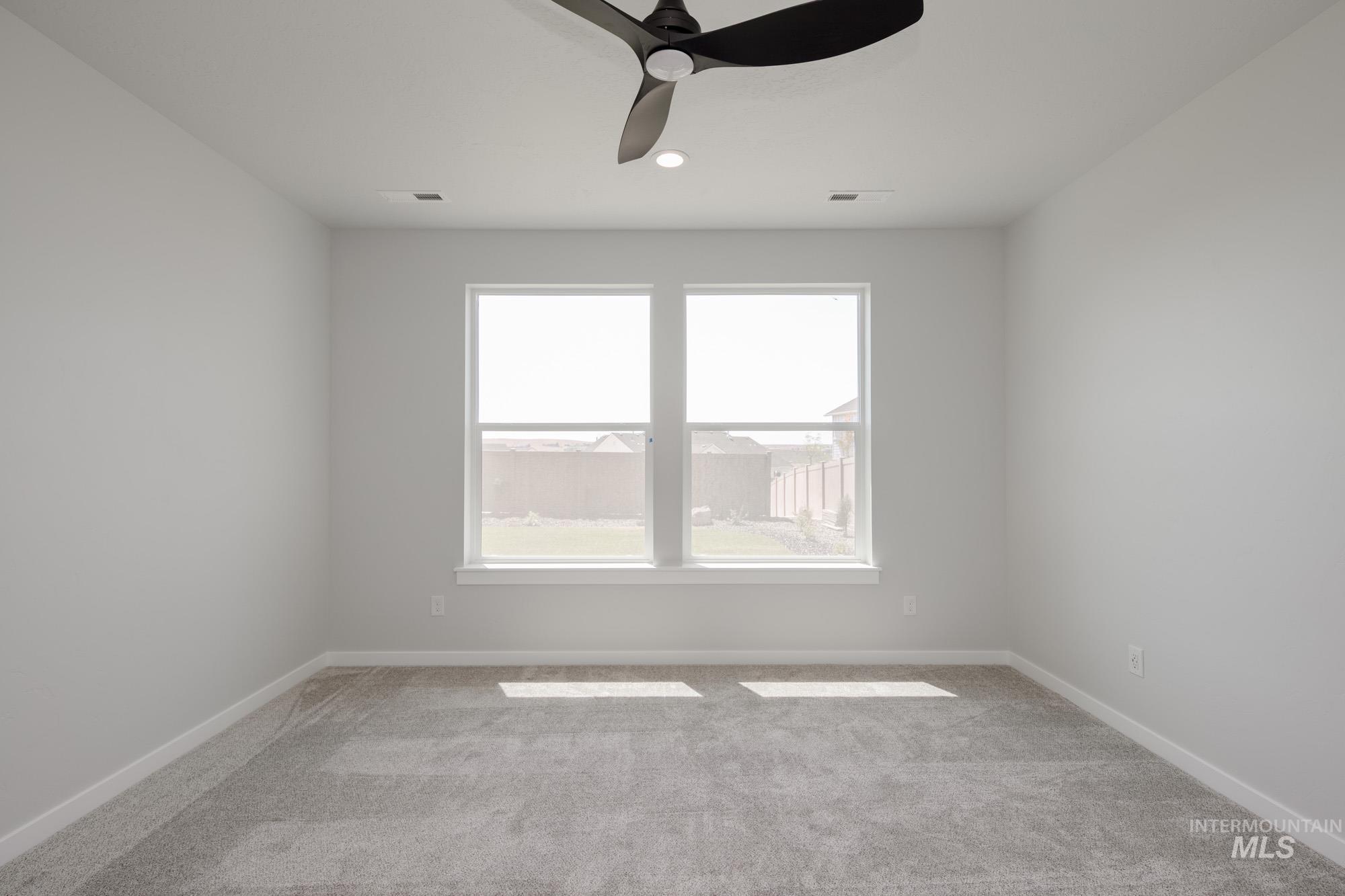 Carpeted spare room featuring a ceiling fan and recessed lighting