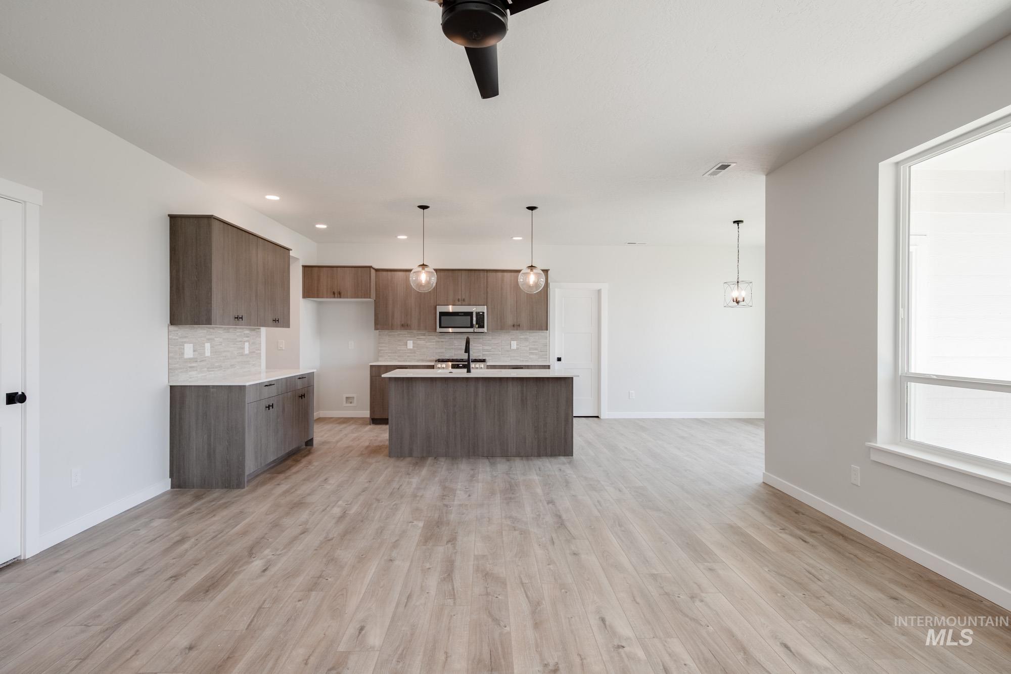 Kitchen featuring tasteful backsplash, light countertops, light wood finished floors, and recessed lighting