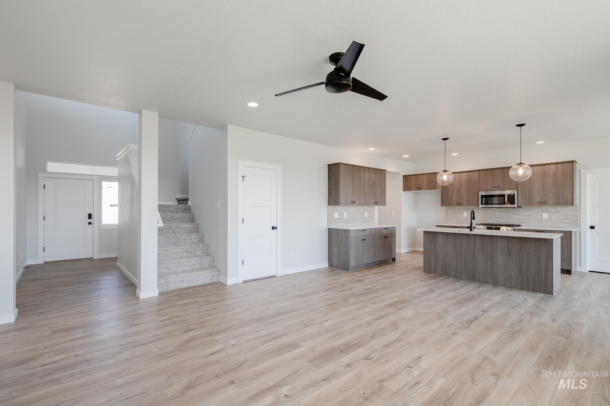 Kitchen with open floor plan, decorative backsplash, light wood-style flooring, and recessed lighting