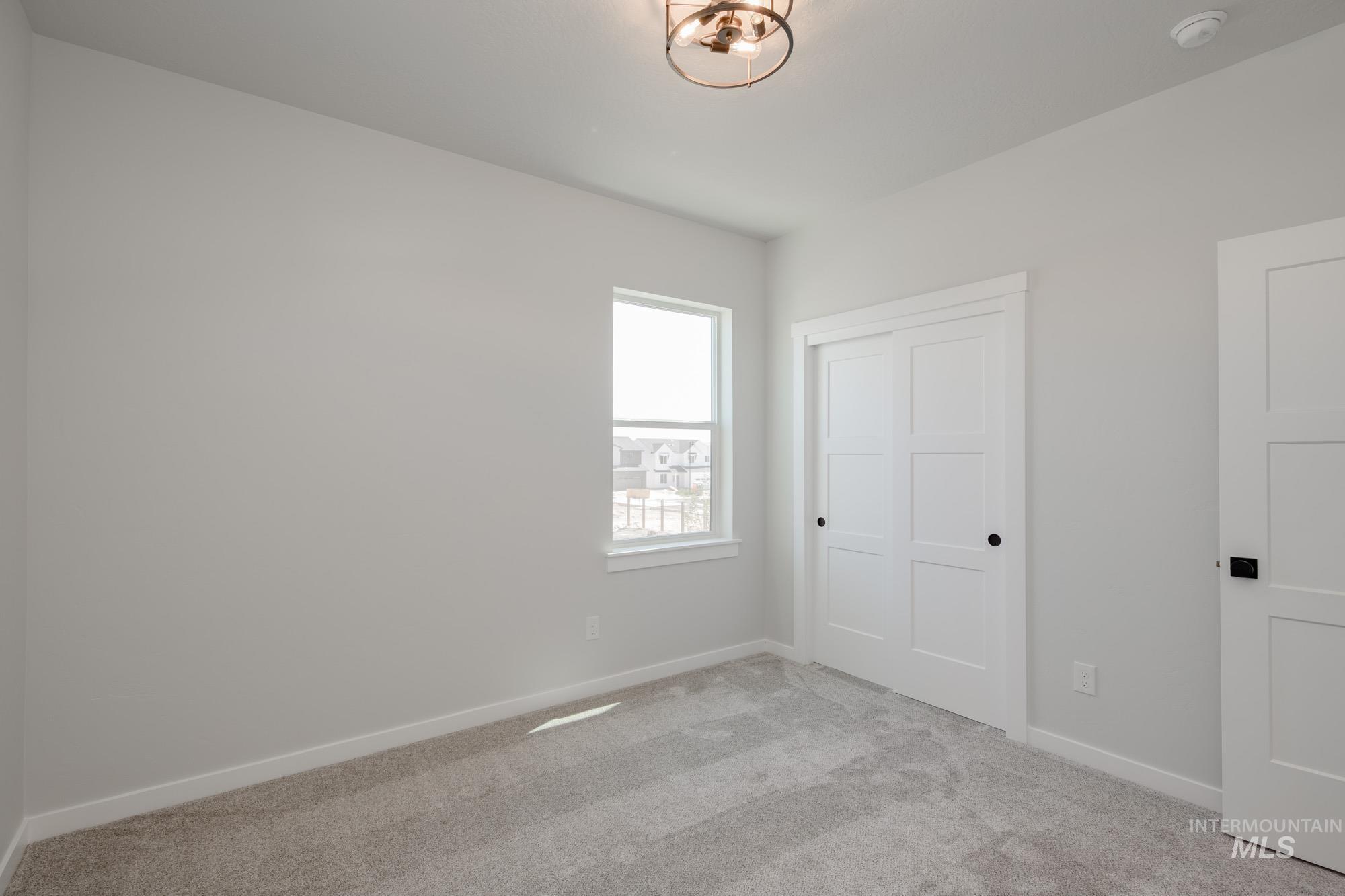 Unfurnished bedroom featuring light carpet and a closet