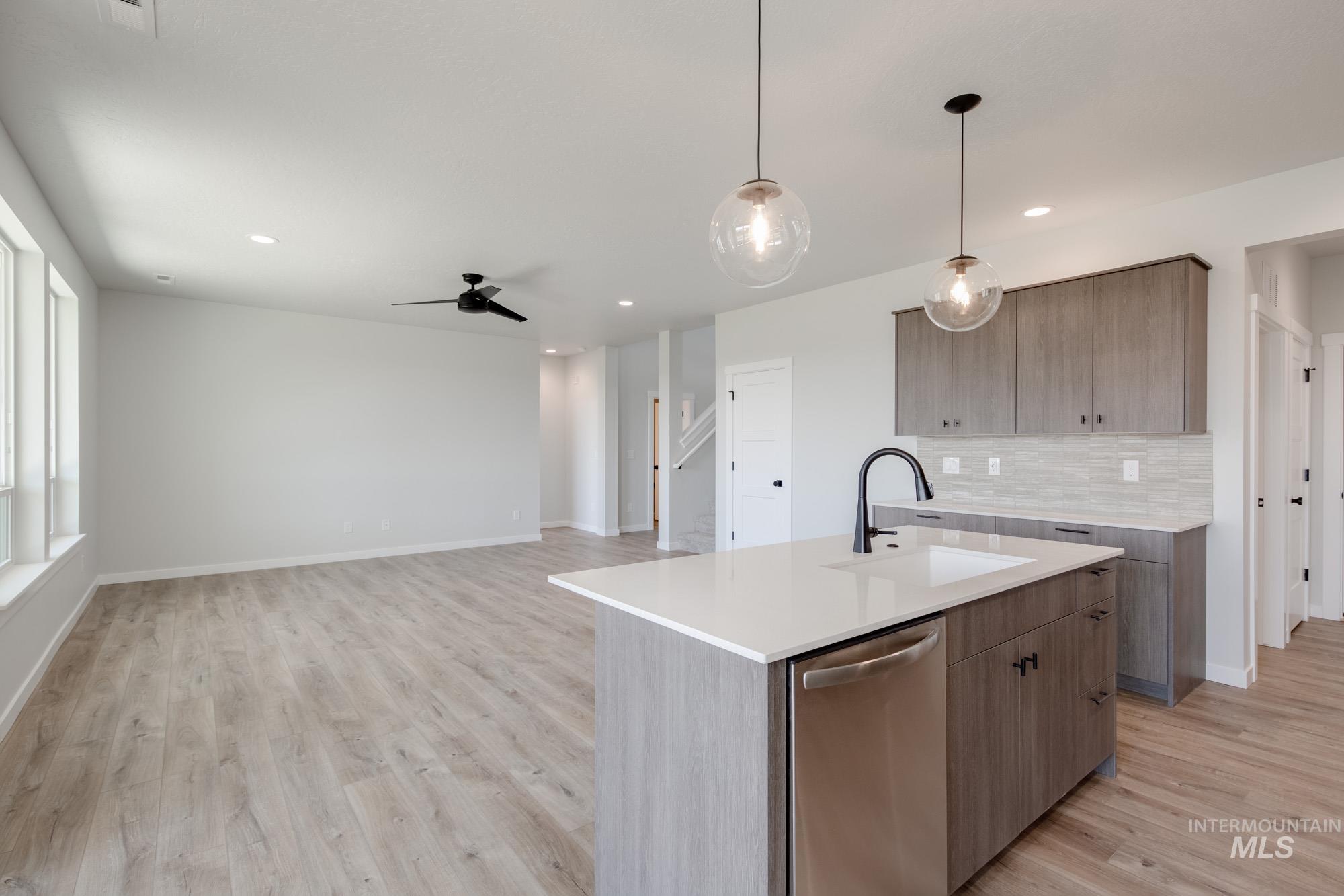 Kitchen with stainless steel dishwasher, modern cabinets, light countertops, decorative backsplash, and recessed lighting