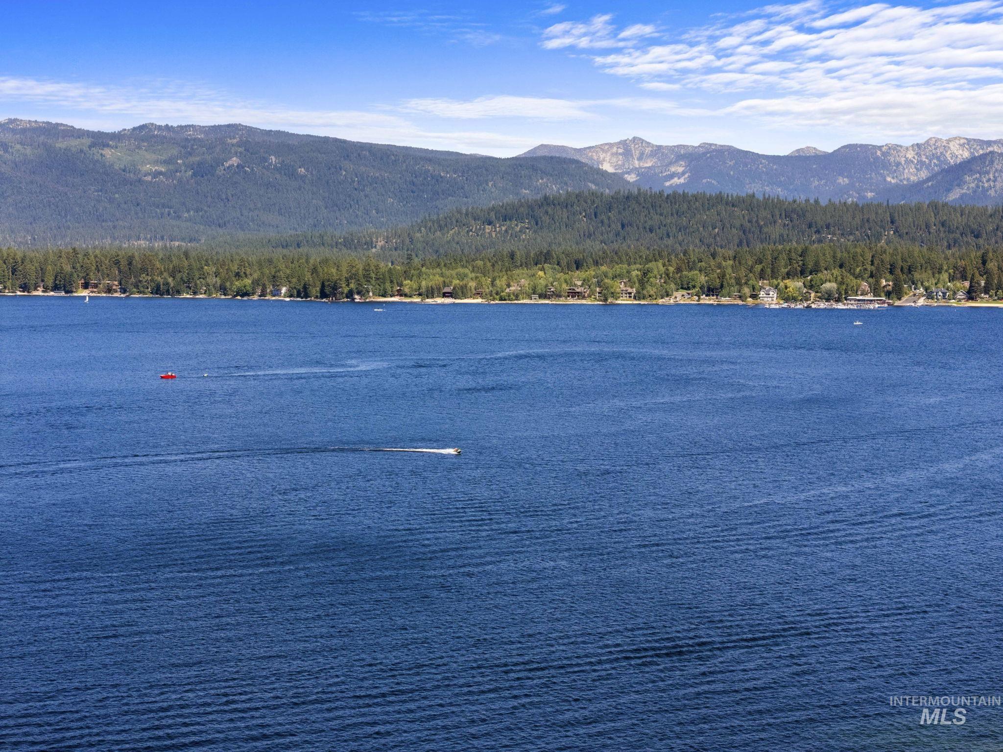 Water view with a mountain backdrop and a heavily wooded area
