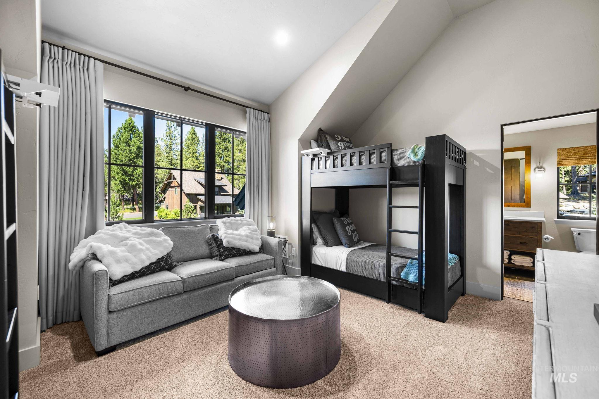 Bedroom featuring light carpet, multiple windows, and high vaulted ceiling