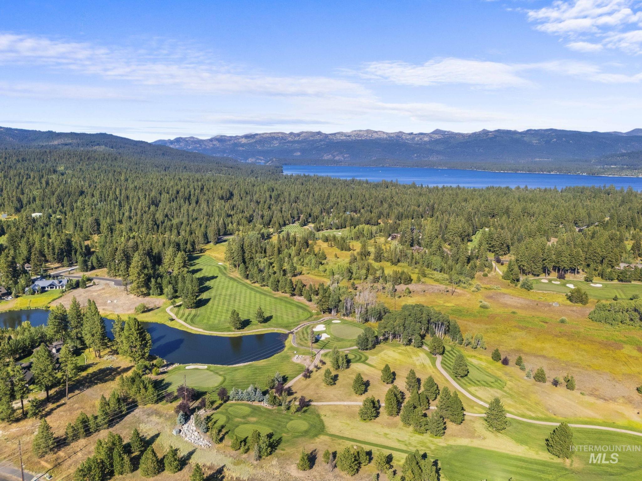 Aerial overview of property's location featuring a water and mountain view and a golf course