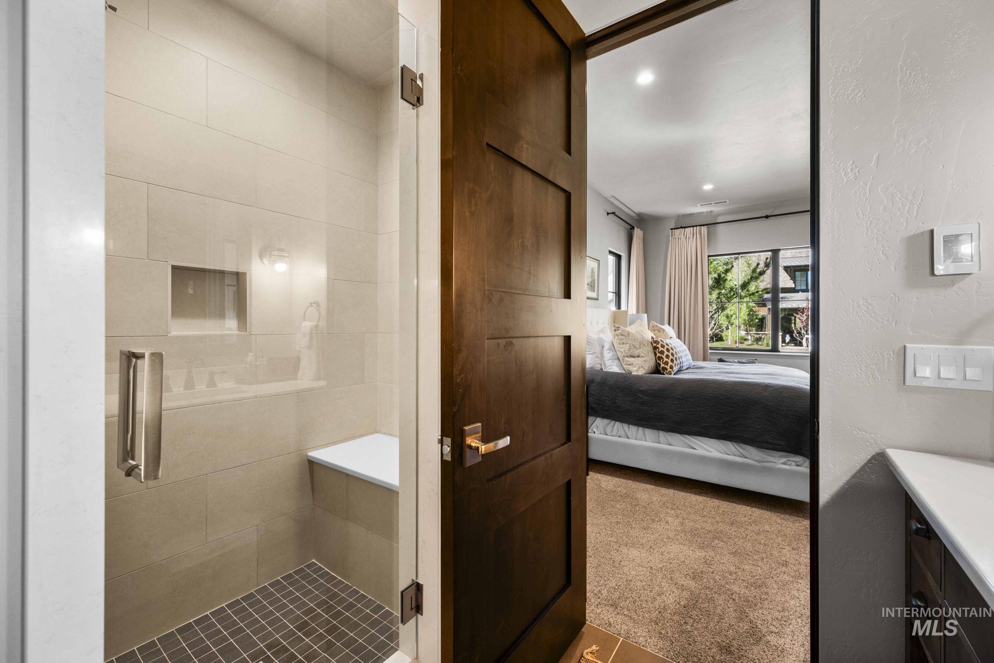 Full bathroom with connected bathroom, a stall shower, recessed lighting, a textured wall, and vanity