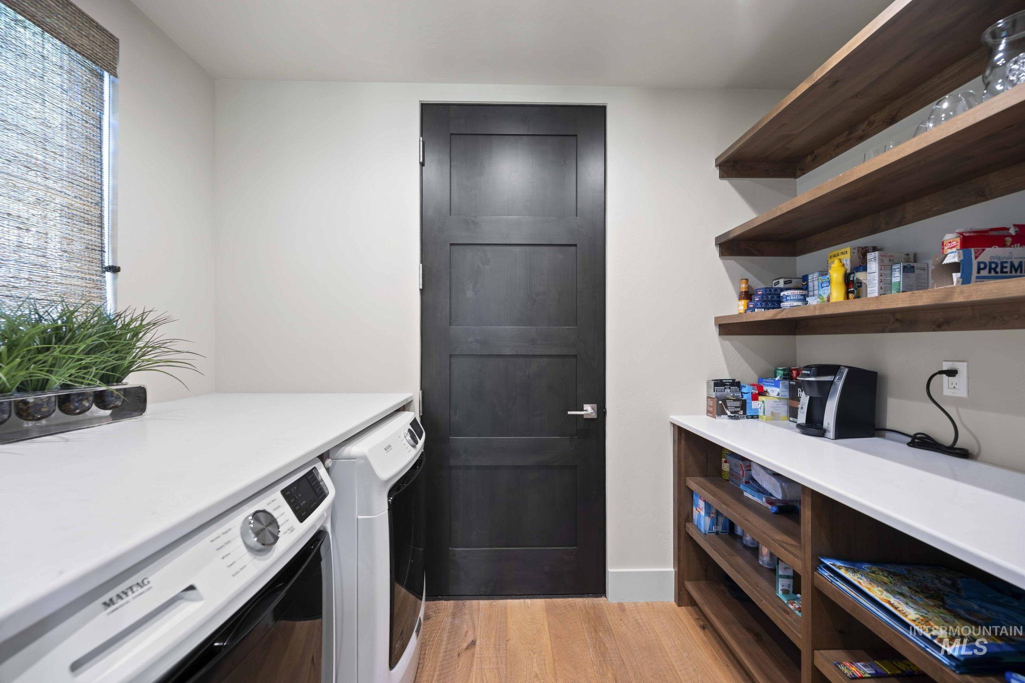 Washroom featuring light wood finished floors and washing machine and dryer