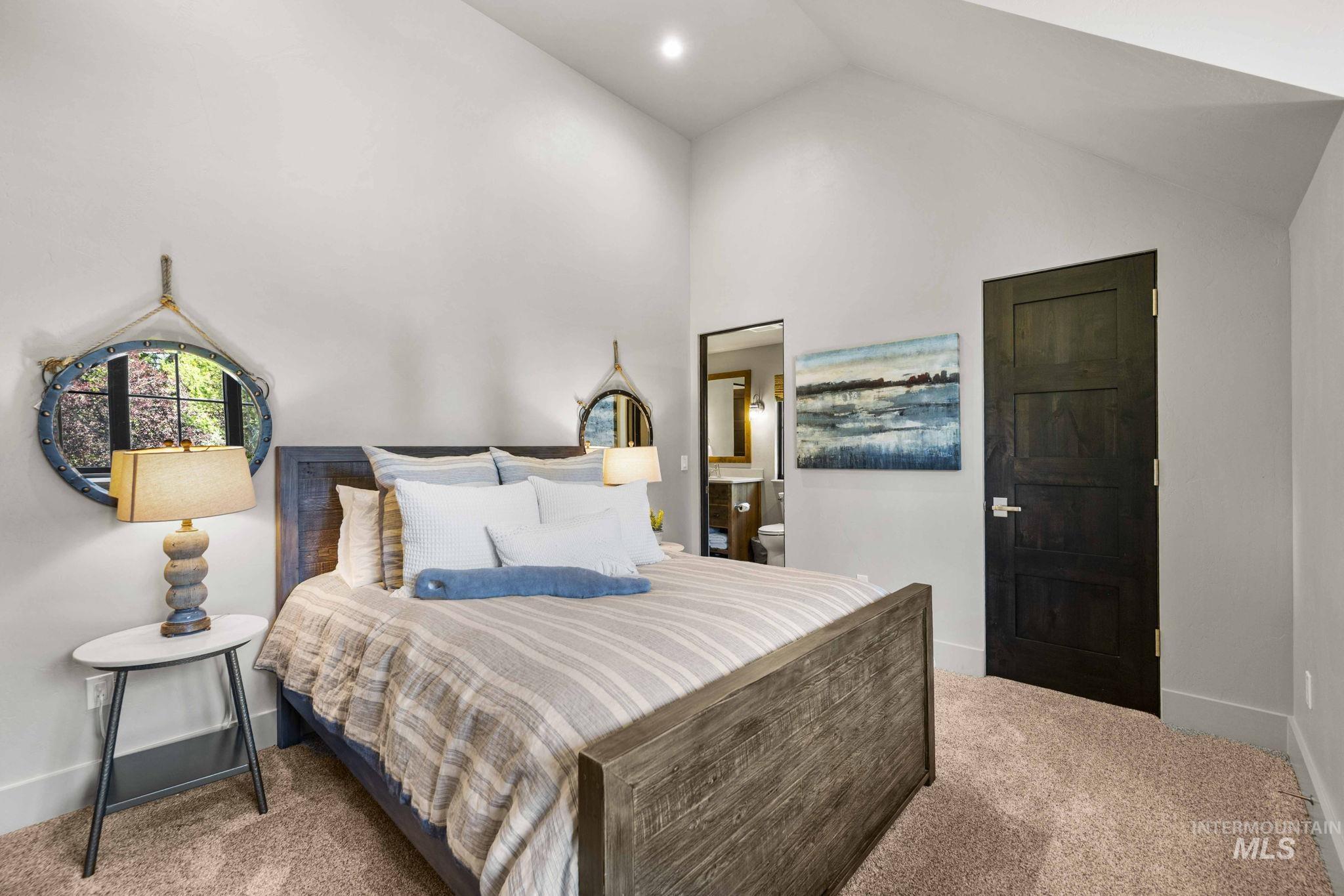 Bedroom featuring light colored carpet and high vaulted ceiling