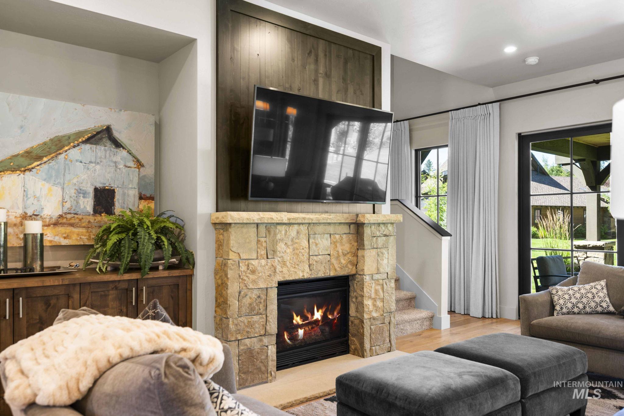 Living room featuring wood finished floors, stairs, and a fireplace