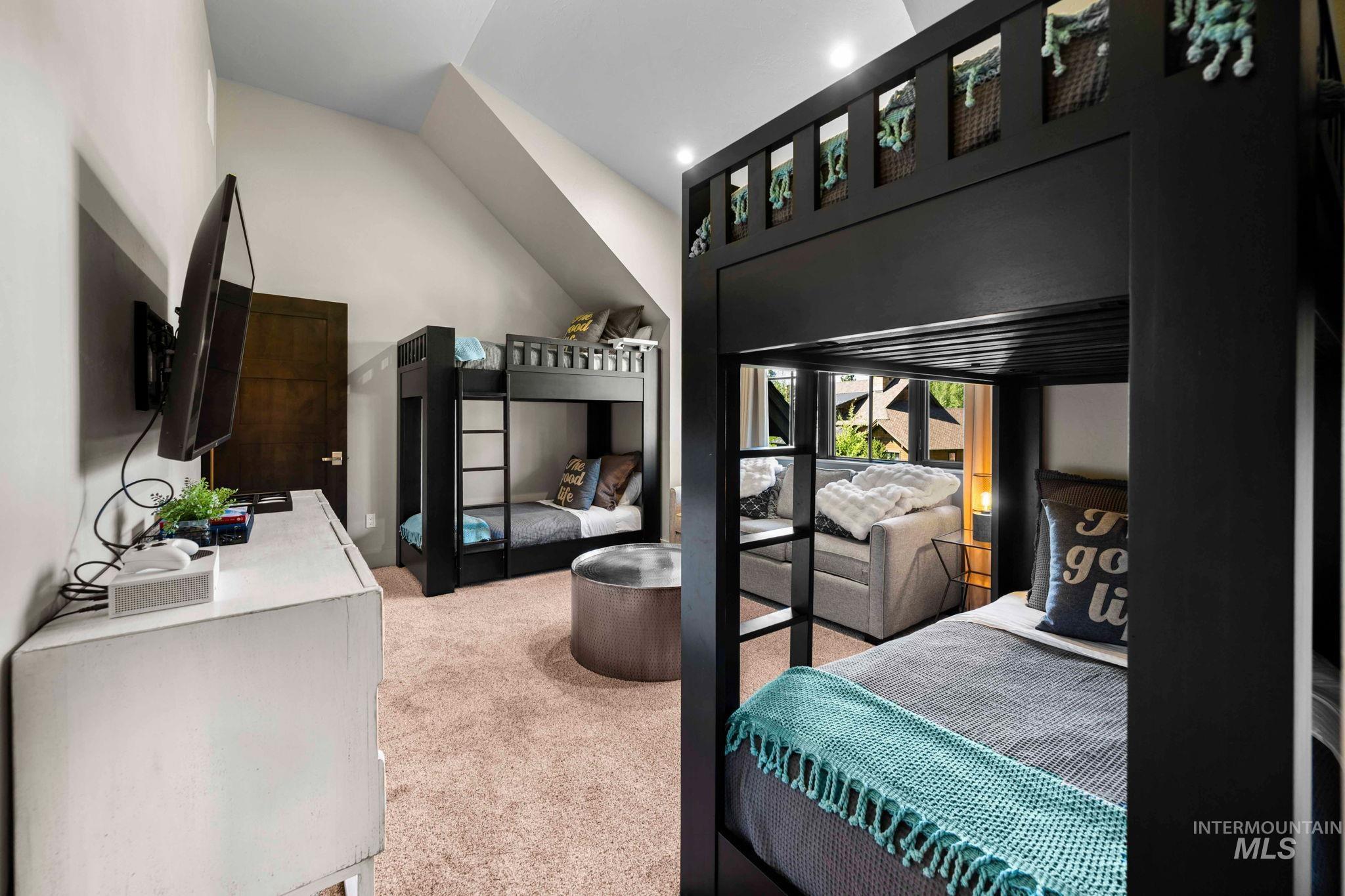 Bedroom with light colored carpet and vaulted ceiling
