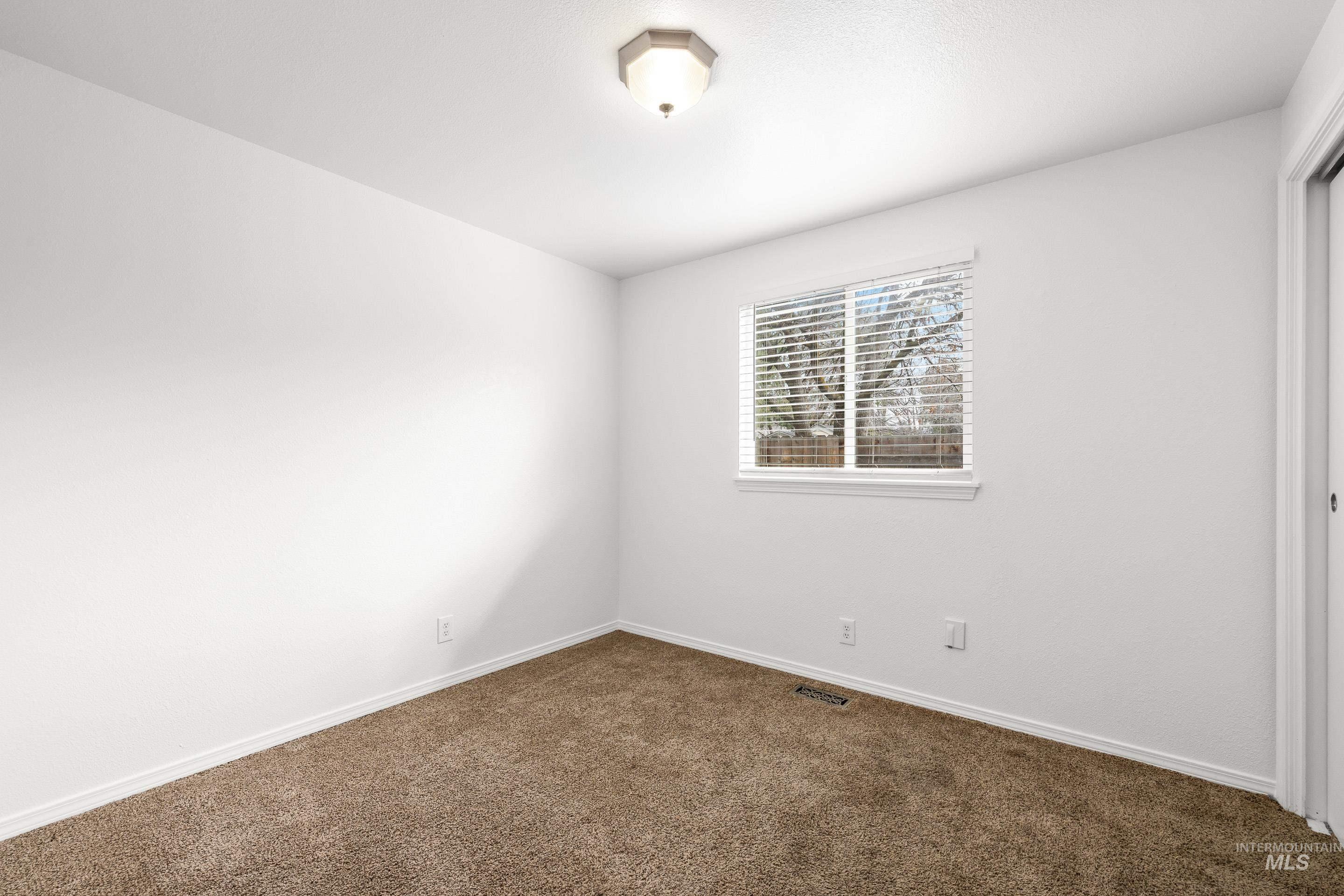 Unfurnished room with baseboards and dark colored carpet