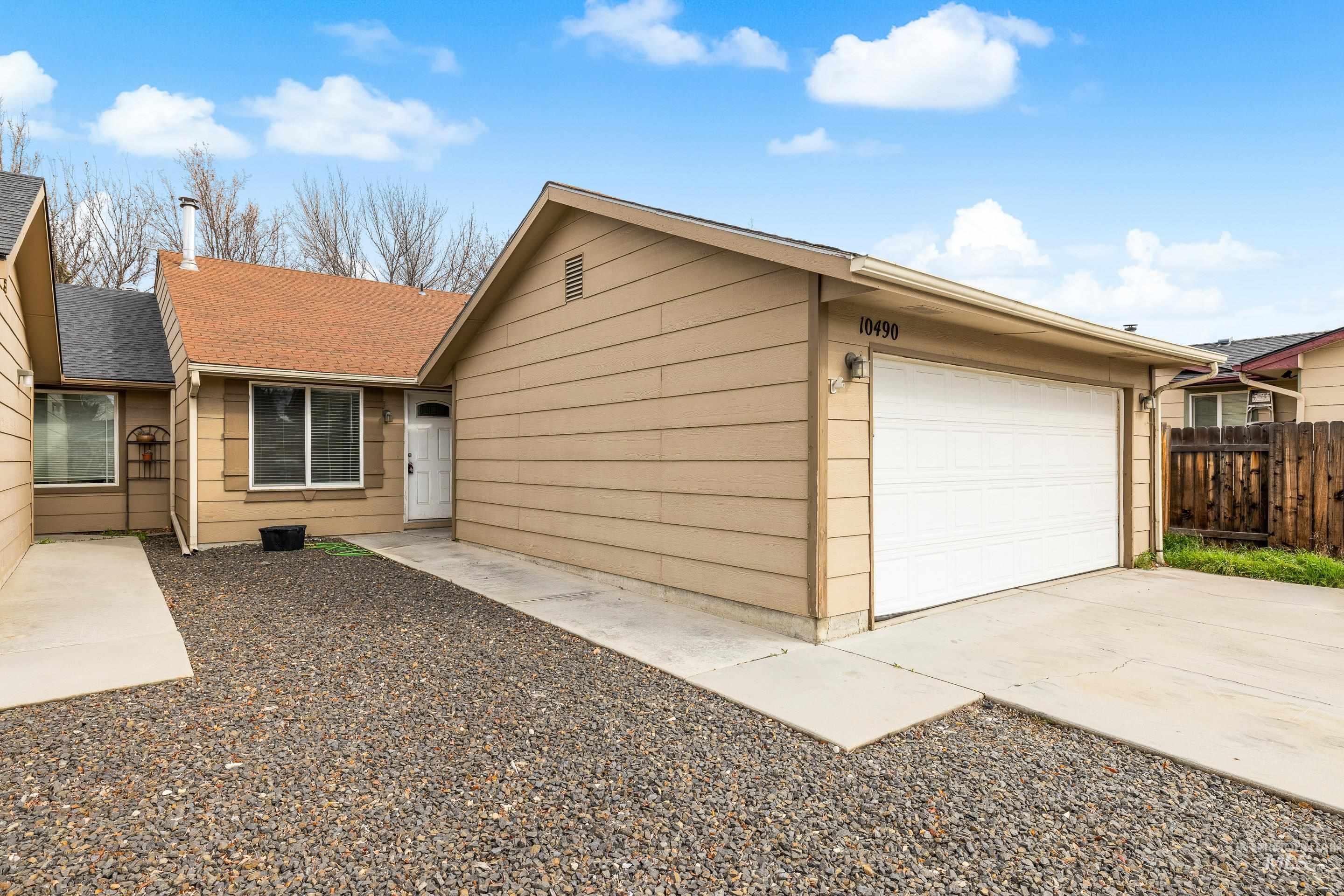 View of front of property with concrete driveway, a shingled roof, and an attached garage