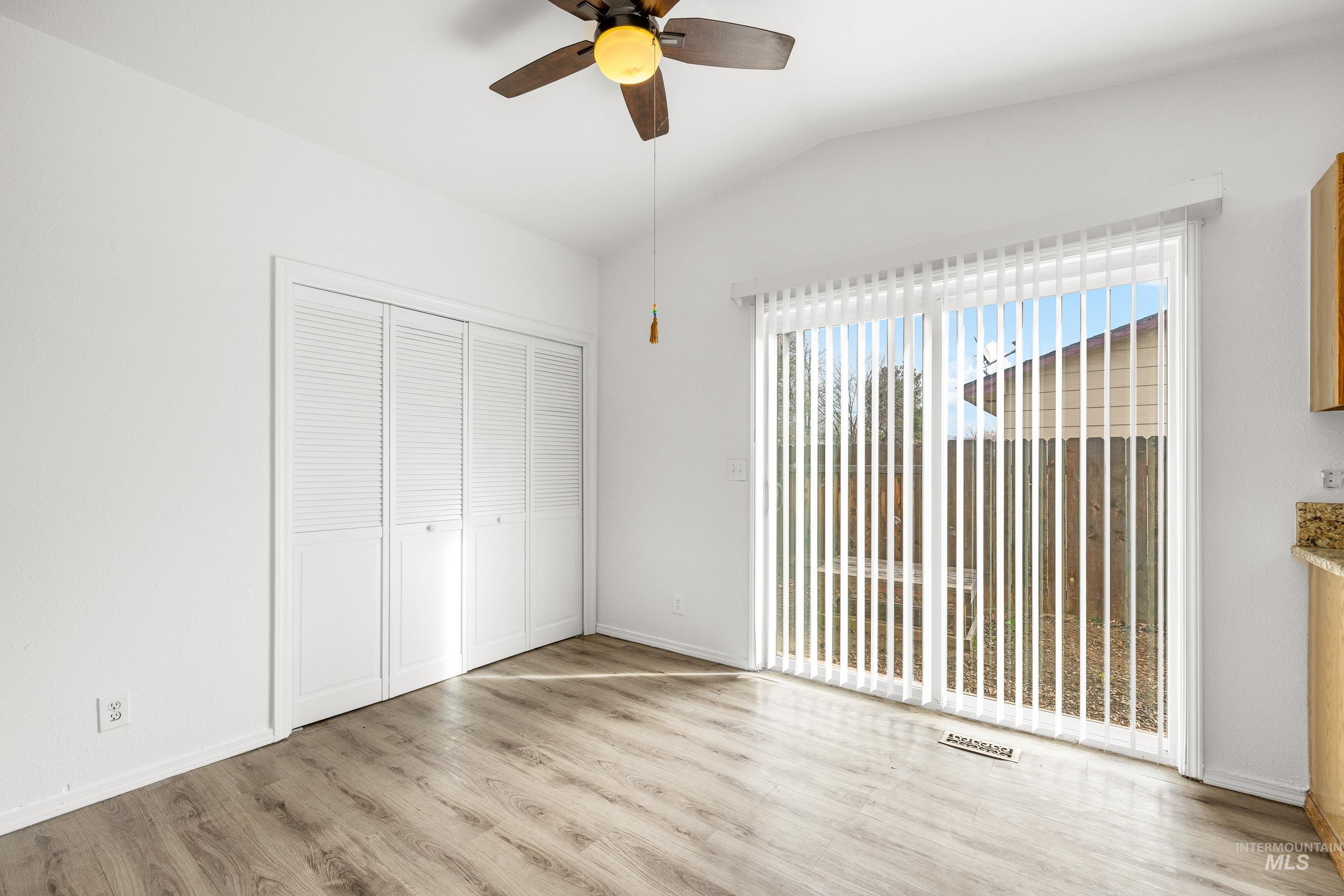 Unfurnished bedroom featuring vaulted ceiling, light wood-type flooring, a closet, and ceiling fan