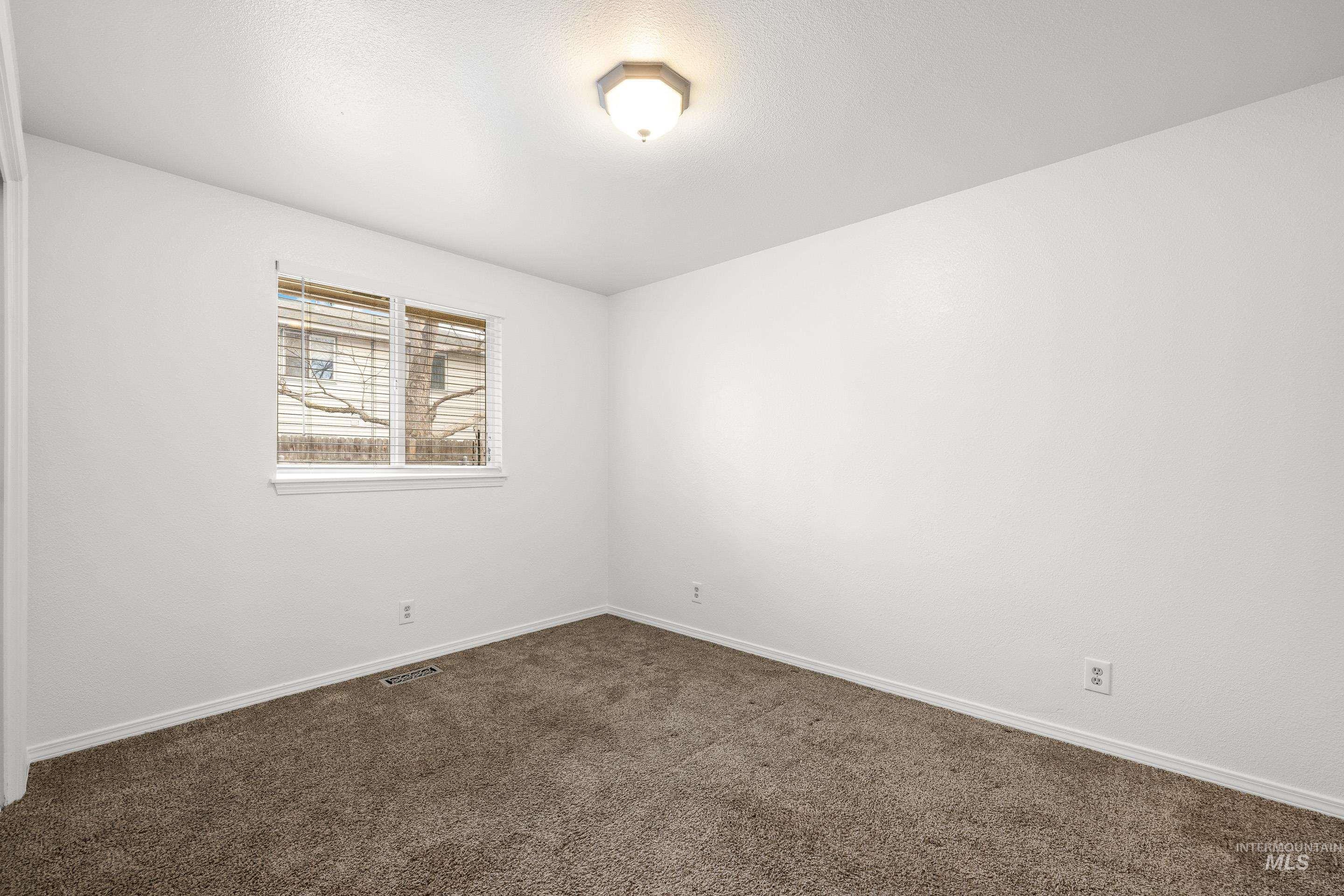 Unfurnished room with baseboards and dark carpet