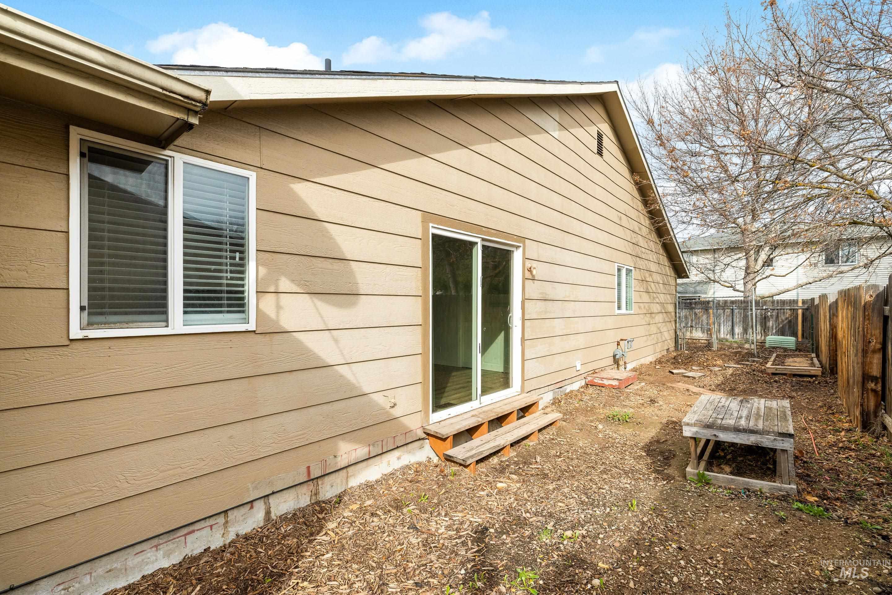 Rear view of house featuring a fenced backyard