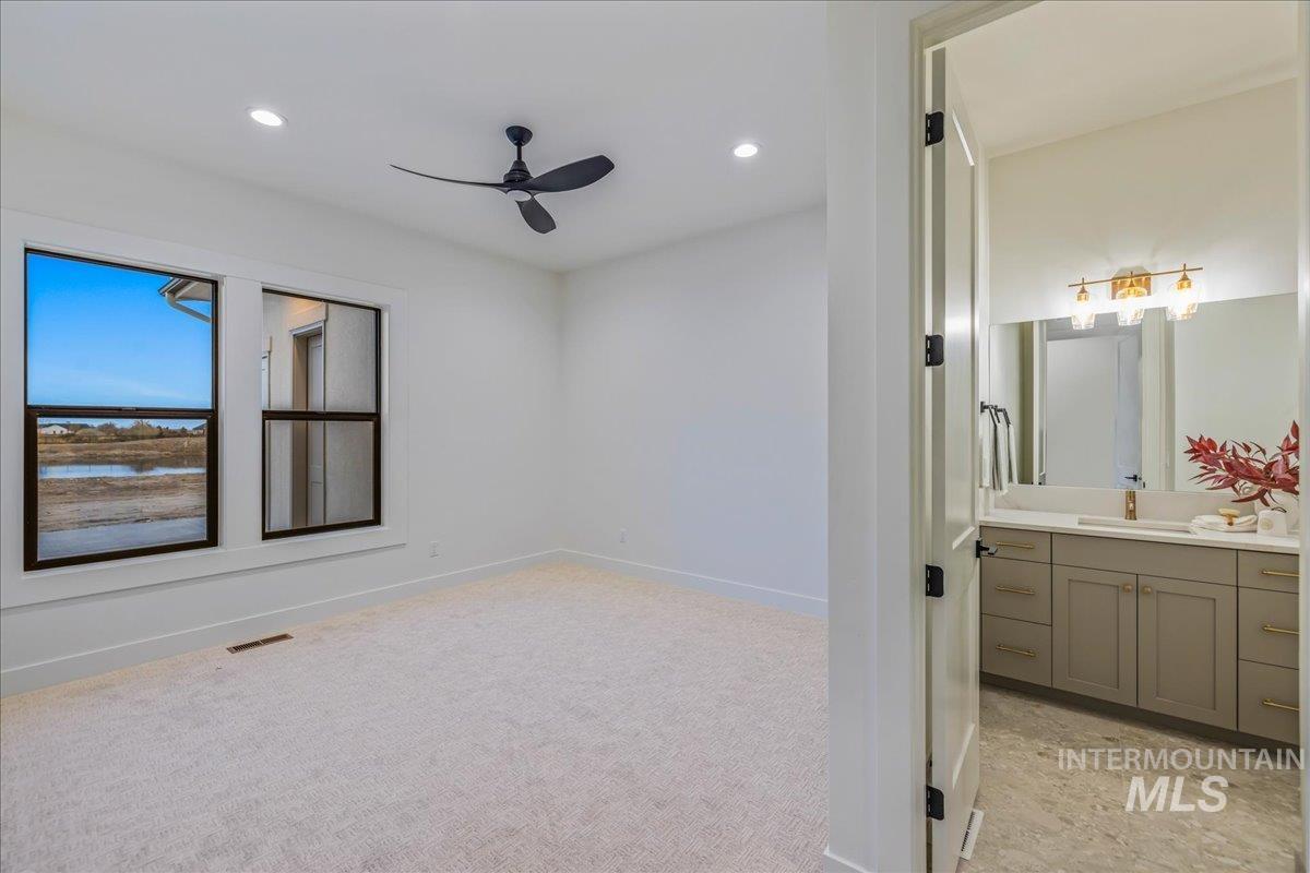 Spare room with a ceiling fan, recessed lighting, light carpet, and a water view