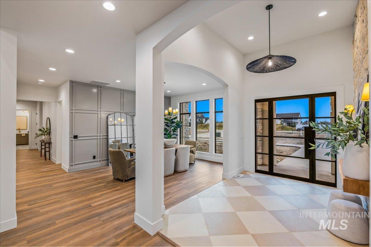 Entrance foyer featuring arched walkways, recessed lighting, and light wood-style flooring