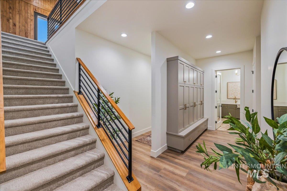 Stairs with recessed lighting and wood finished floors