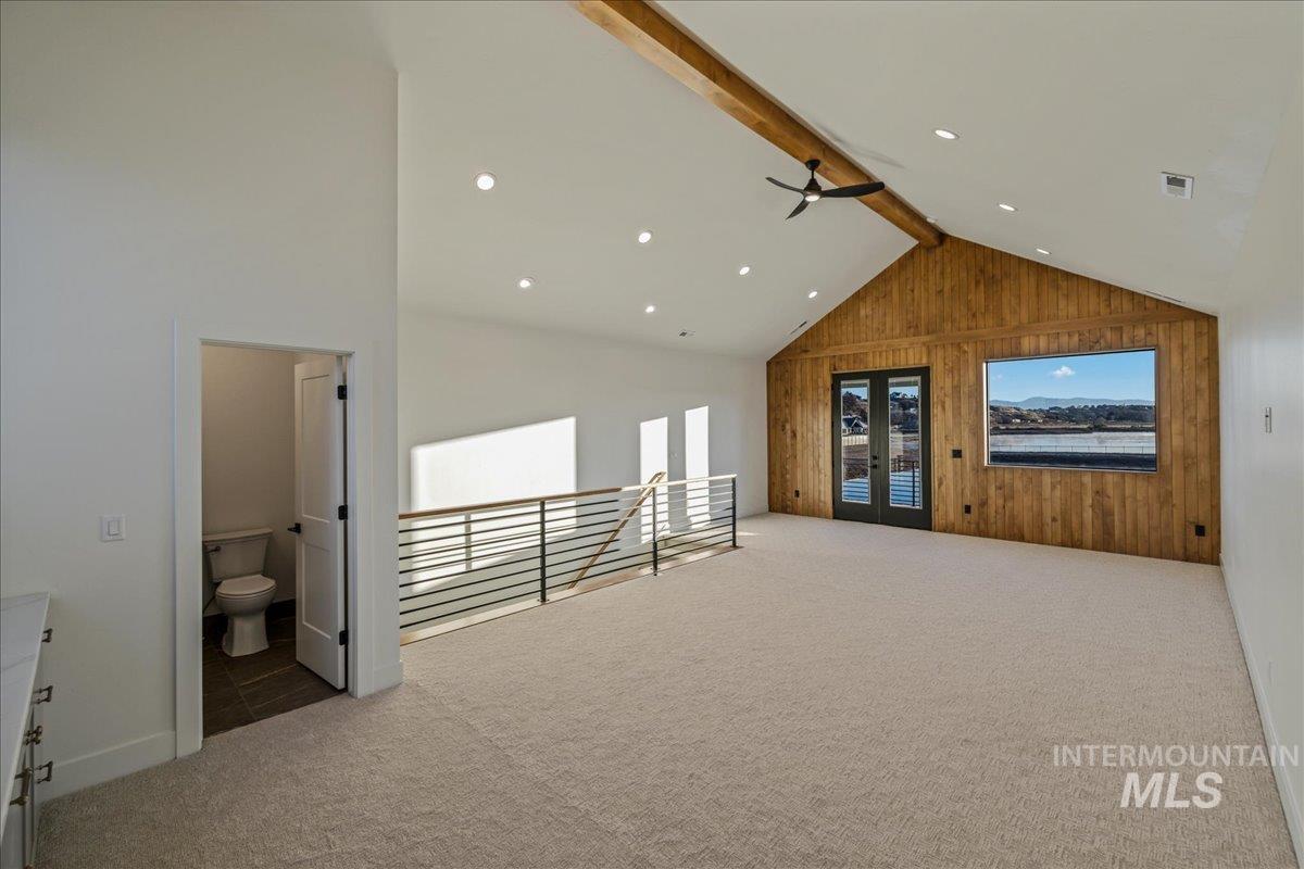 Bonus room with wood walls, light carpet, beamed ceiling, healthy amount of natural light, and recessed lighting