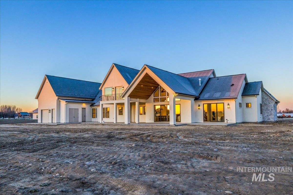 View of front of house with a patio and stucco siding